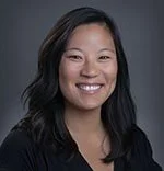 A woman with long black hair smiling at the camera.