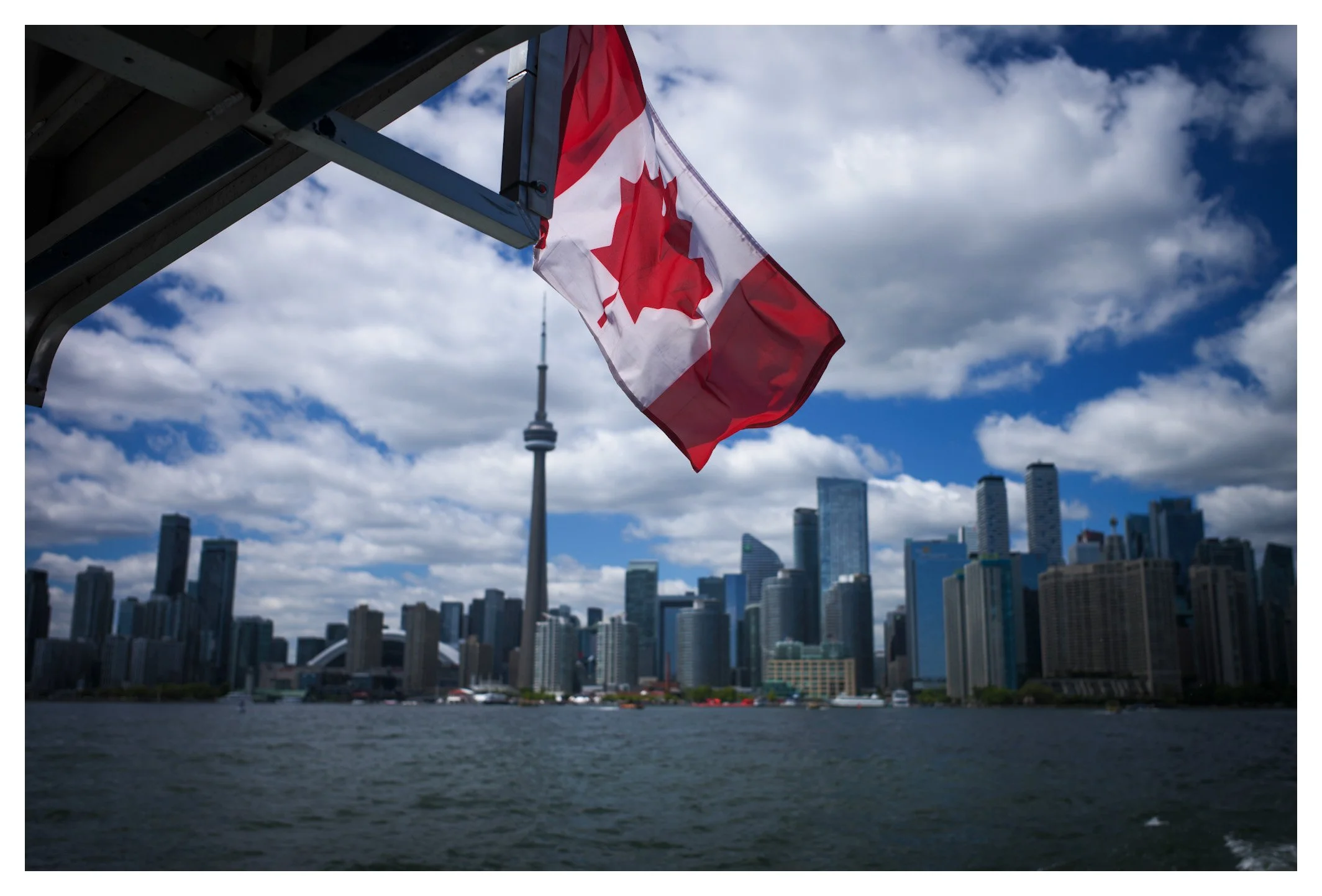 Toronto's skyline is instantly recognizable, crowned by the CN Tower and framed by the Canadian flag. A timeless perspective on one of North America's most vibrant cities.