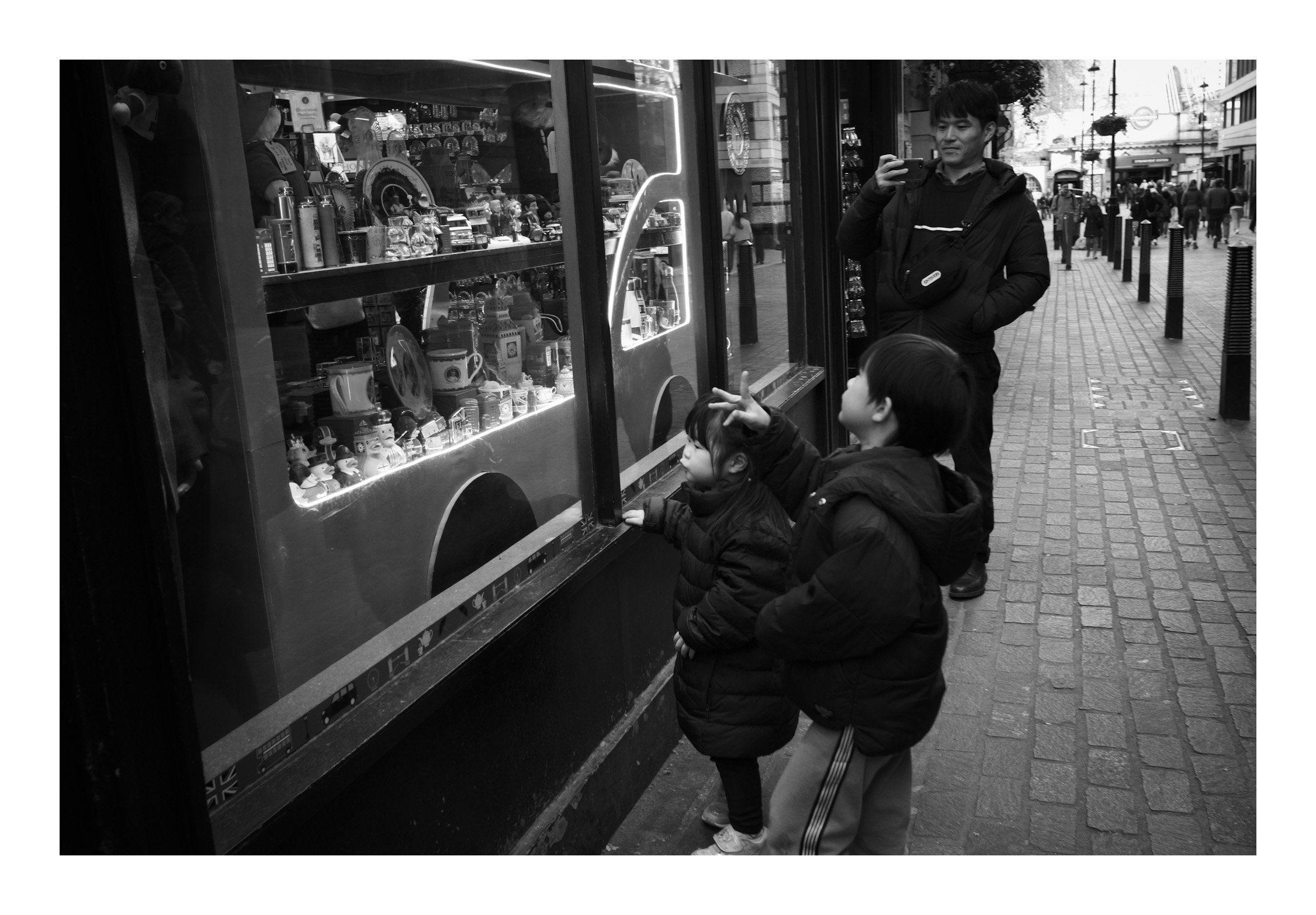 Two children standing in front of a shop window—capturing a moment of curiosity and wonder in the heart of the city.