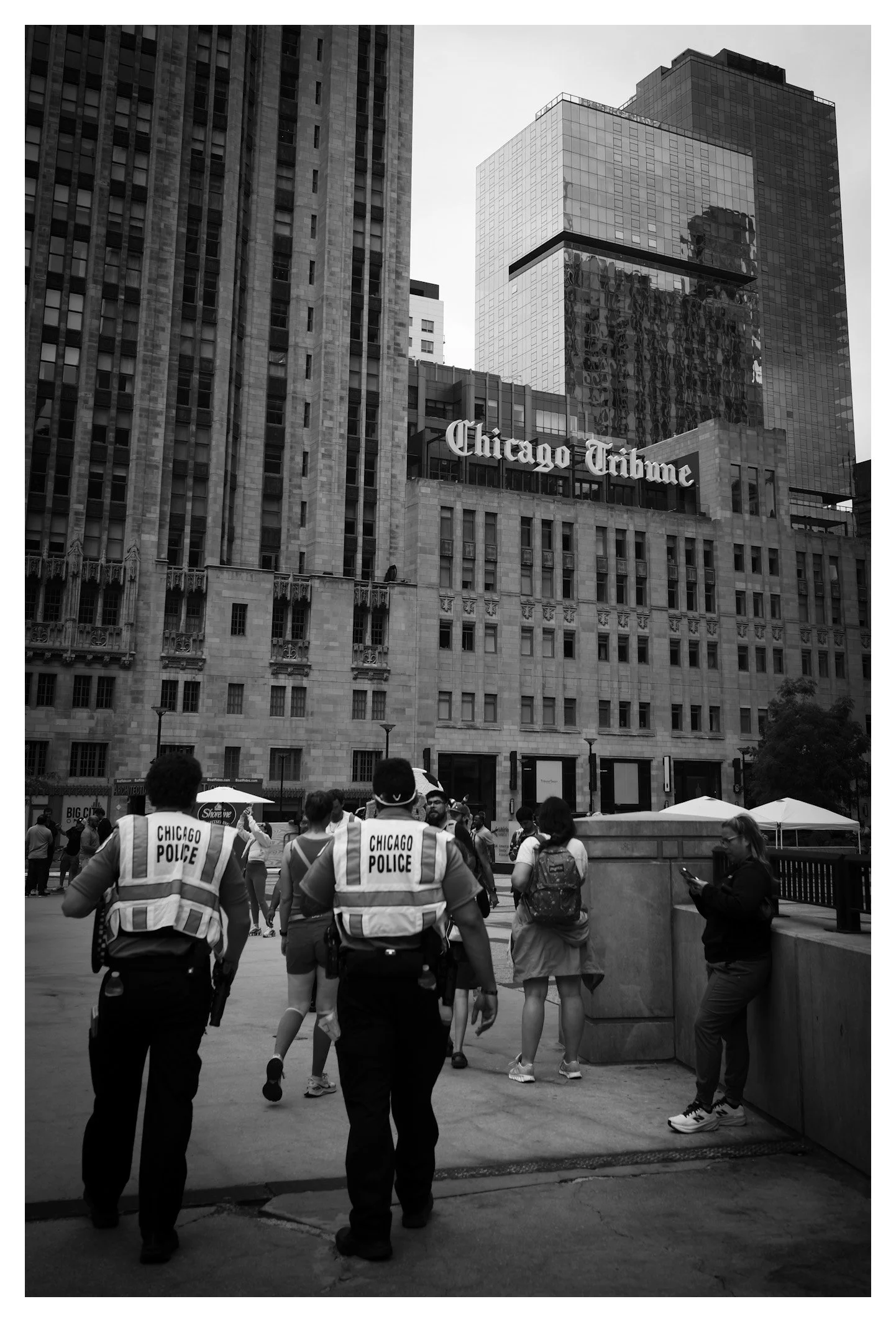 Two Chicago police officers walk through downtown beneath the iconic Chicago Tribune building. A candid moment that reflects the city's unmistakable atmosphere and everyday character.
