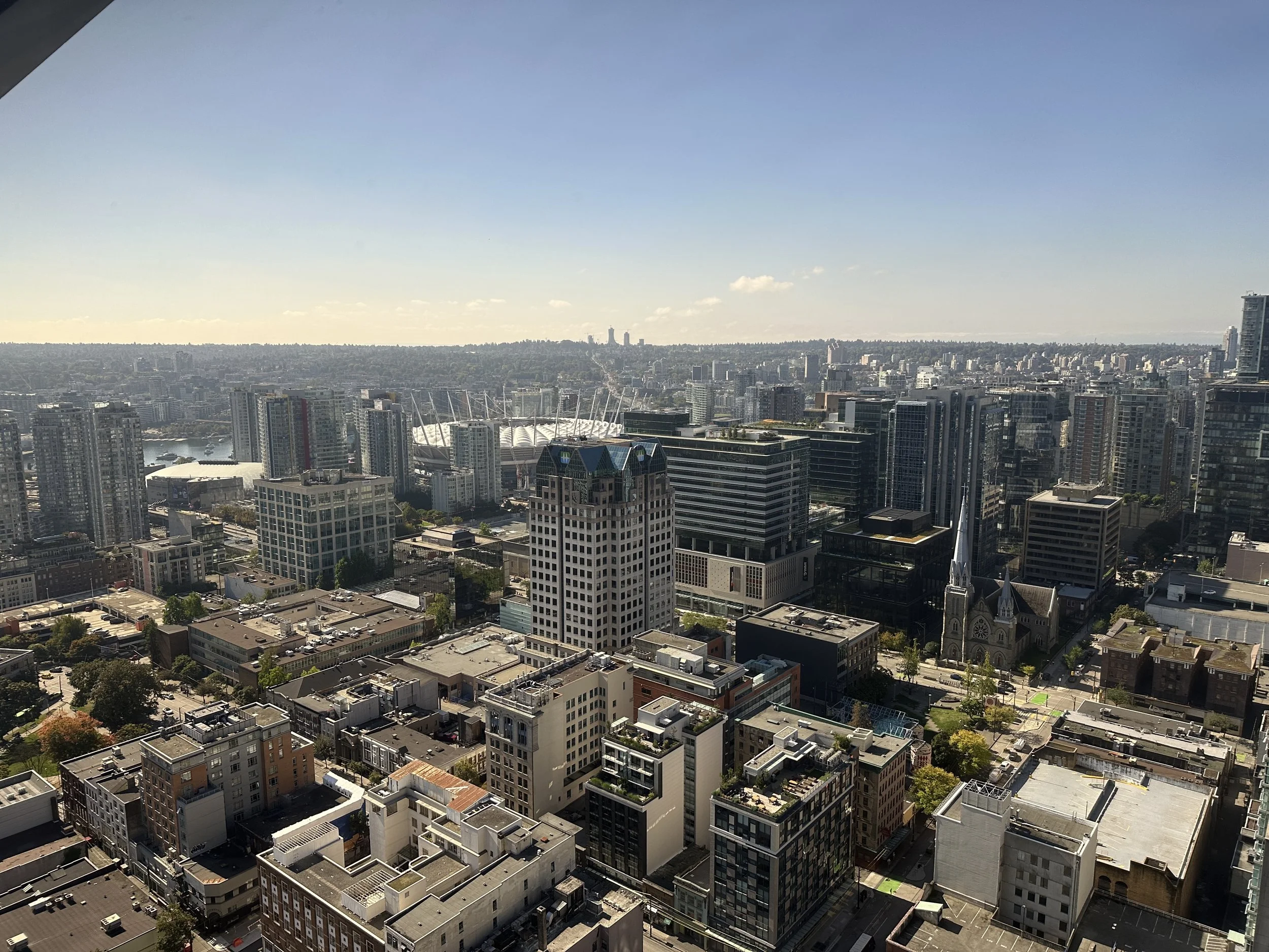 Seen from above, Vancouver unfolds as a modern city framed by water and mountains.
At the center, BC Place Stadium stands out with its distinctive roof and urban presence.
From this perspective, Vancouver feels open, structured, and perfectly balance