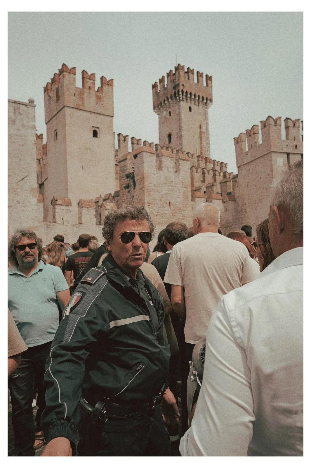 A police officer attempts to manage the crowd in Sirmione.
Amid movement, voices, and summer crowds, he maintains order and focus.
The scene highlights the contrast between tourist energy and everyday responsibility.