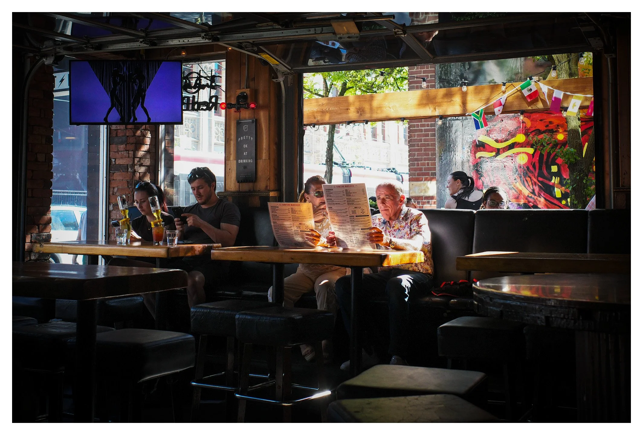 Some people scroll through their phones, others study the menu, while sunlight quietly fills the room. Street photography isn't only found outdoors—it also lives in these unscripted moments behind the glass.