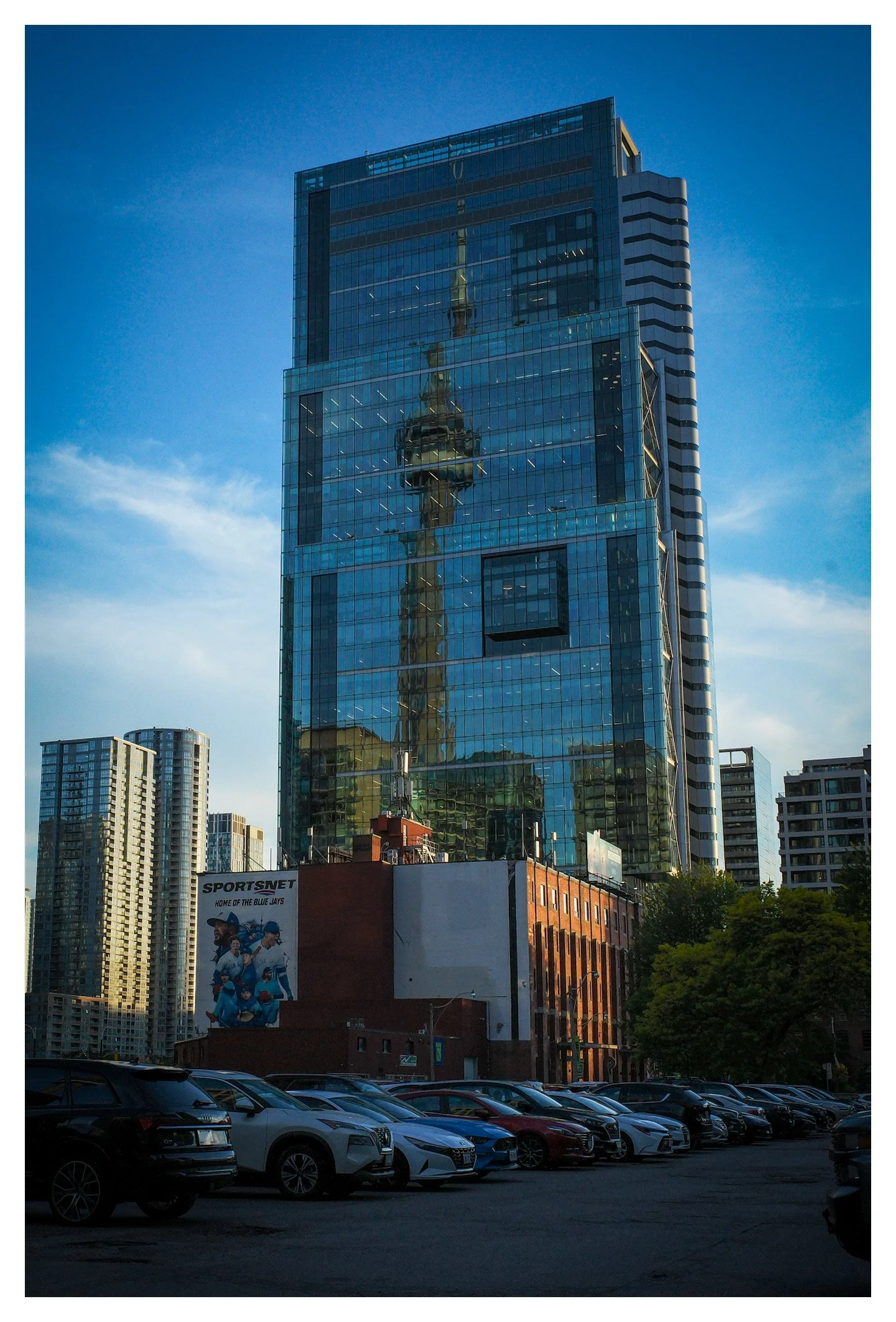 Reflected in the mirrored glass, the CN Tower becomes part of Toronto's modern architecture. A simple composition that highlights the city's unique urban identity.