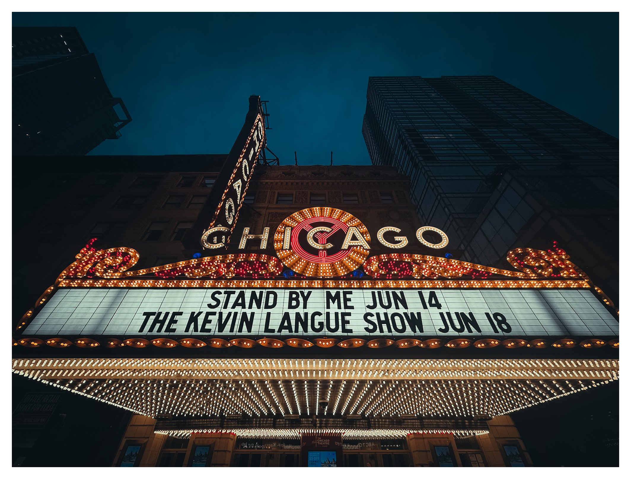 As night falls, the legendary Chicago Theatre becomes the center of attention, framed by towering skyscrapers and thousands of glowing lights. A moment that captures the city's unmistakable energy and character.