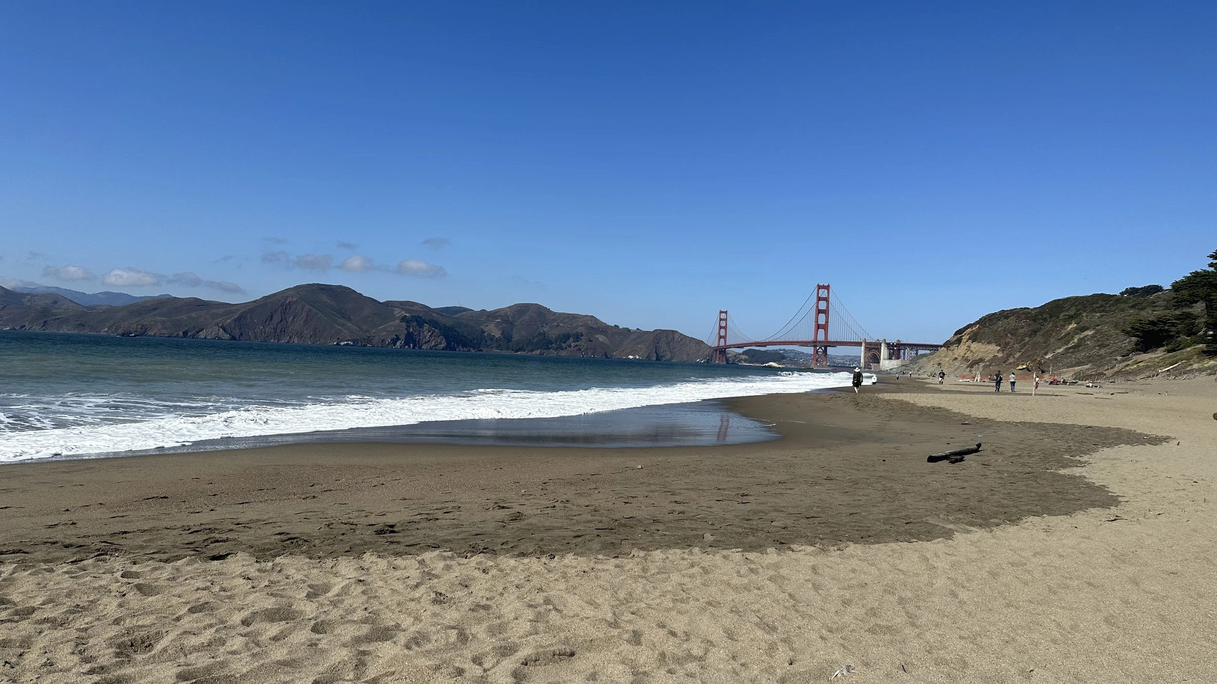 Baker Beach offers one of the most iconic coastal views in San Francisco.
With the Golden Gate Bridge rising in the distance, ocean, sand, and sky create a powerful sense of openness.
It’s a place where the city fades away and nature takes over—raw, 