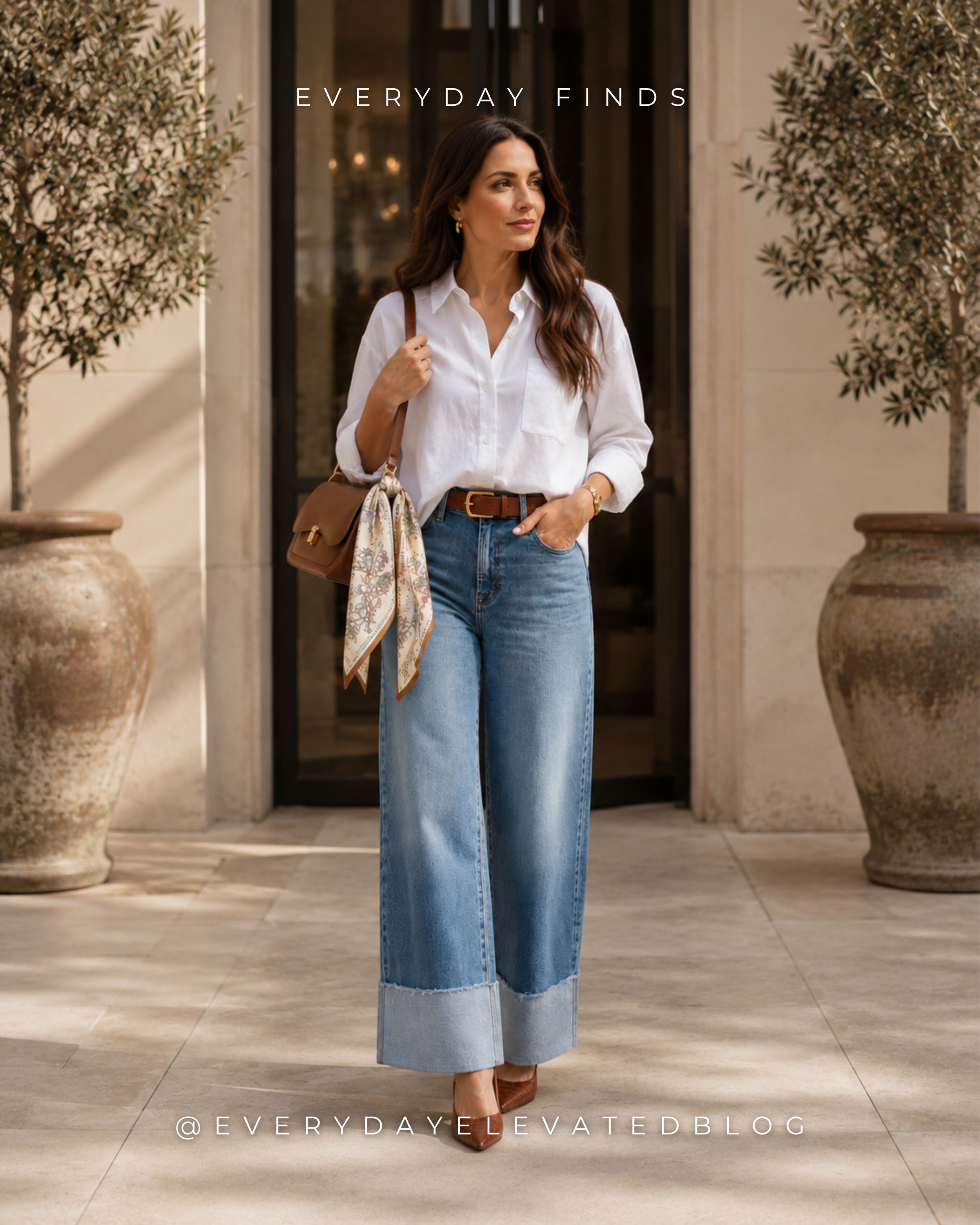 Woman wearing an elevated casual outfit with a white button-down shirt, cuffed wide-leg jeans, brown pointed-toe heels, brown belt, structured handbag and printed scarf.