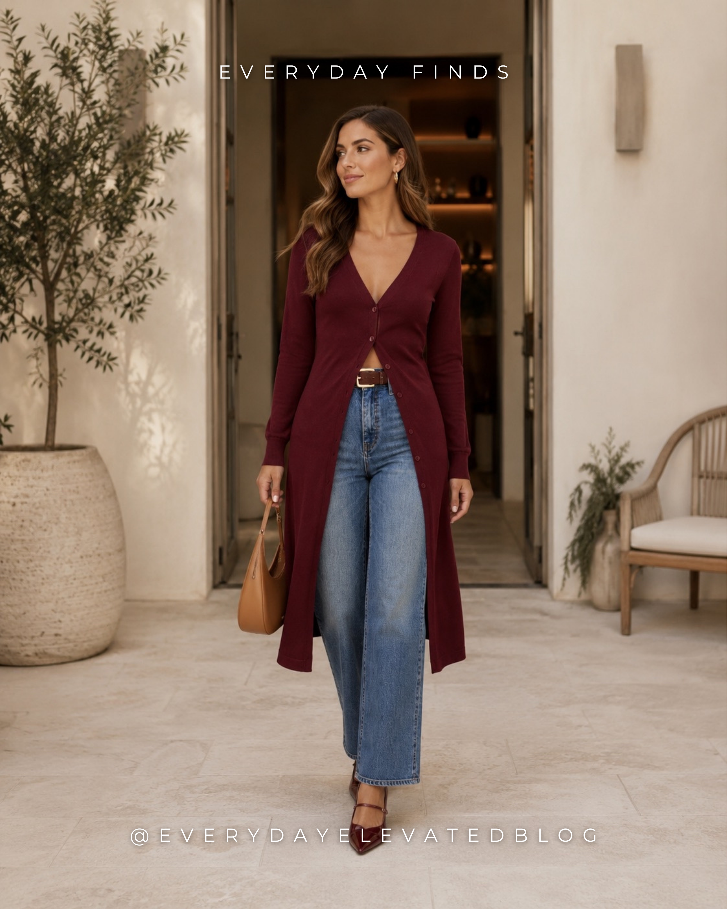 Woman wearing a burgundy cardigan outfit with wide leg jeans, burgundy slingback heels, a cognac leather shoulder bag, brown leather belt, and gold hoop earrings in a luxury outdoor setting.
