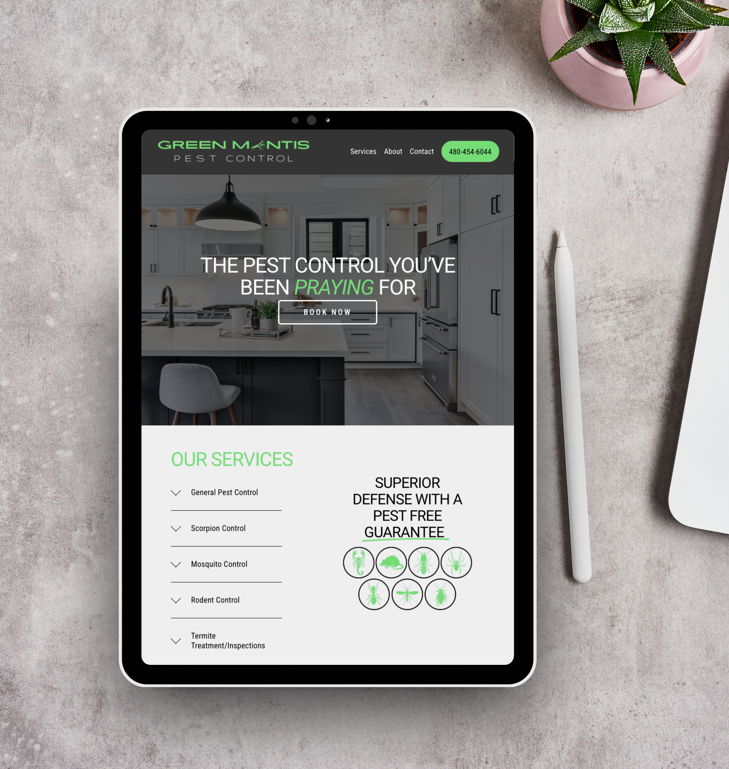 A tablet displaying a pest control service website on a desk, with a white pen and a pink potted plant nearby.