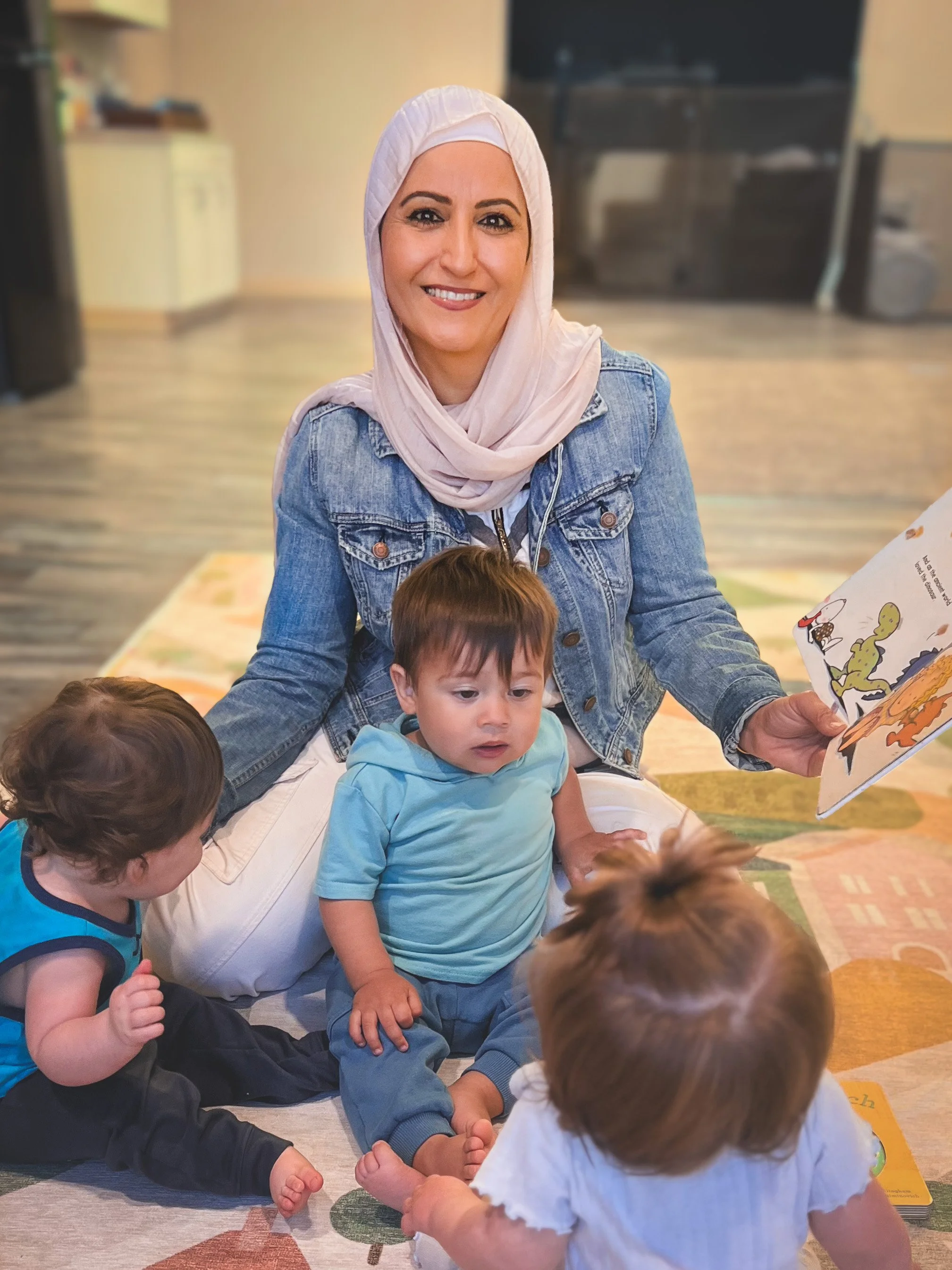 AGTO preschool teacher with 14 years of experience reading to infant and toddler group during story time at A Good Time Out in Bakersfield, CA