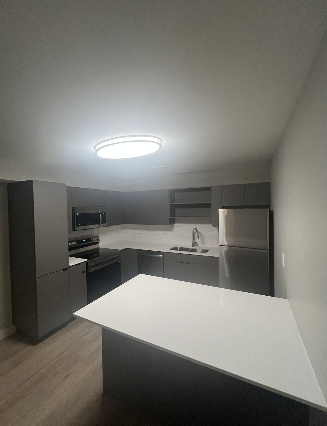 Kitchen restored and remodeled by First Choice Restorations & Services LLC, featuring repaired cabinets, countertops, and lighting.