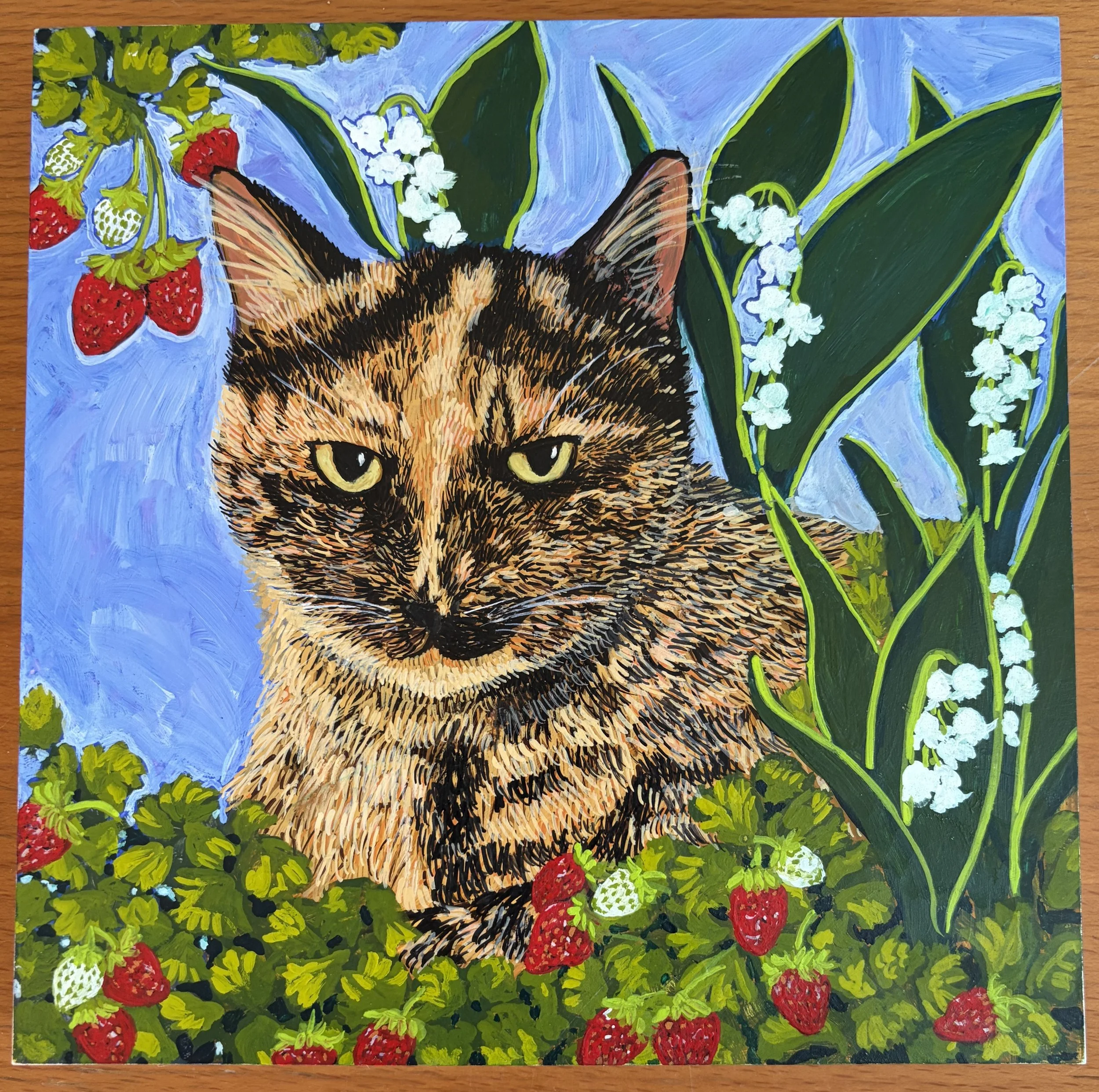 Painting of a cat's face surrounded by green leaves, white flowers, and red raspberries on a blue background.