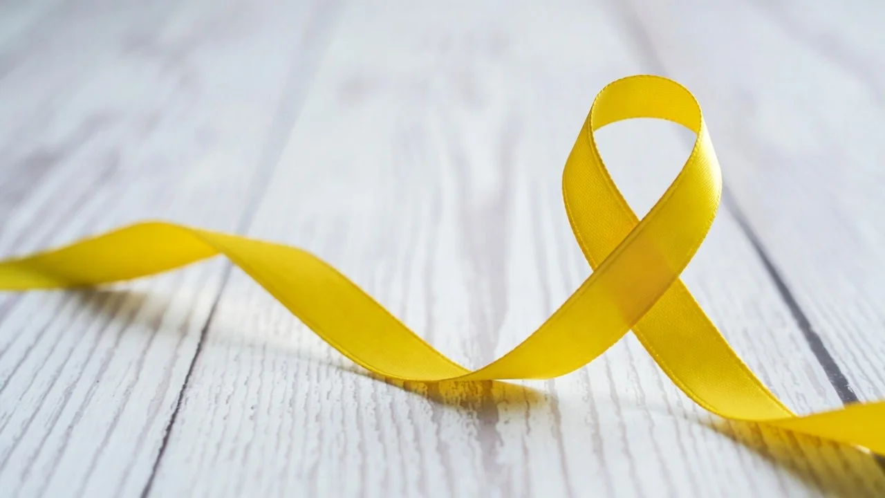 Ruban jaune formant un ruban de sensibilisation sur un fond de surface en bois blanc.