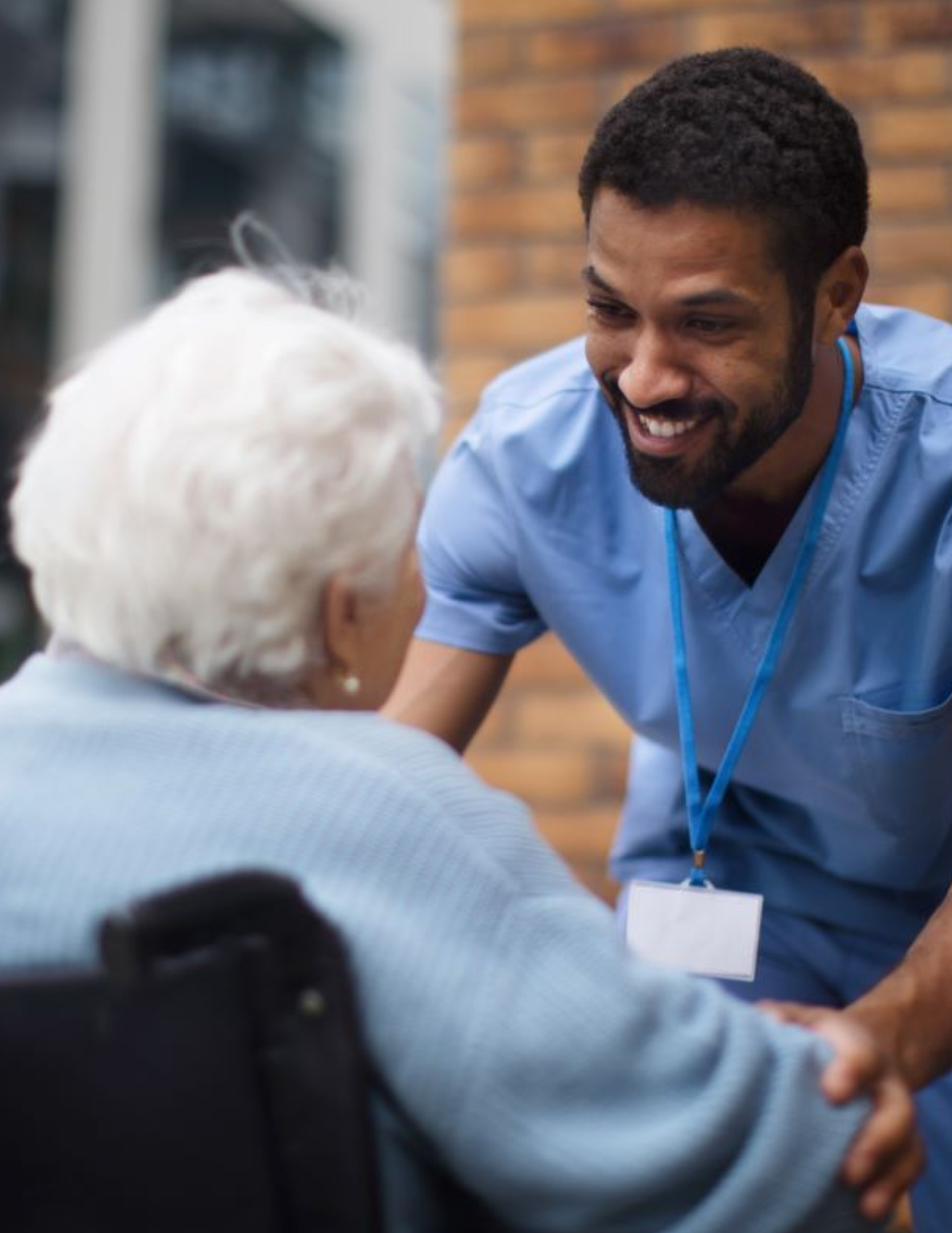 CNA in maroon scrubs with stethoscope providing compassionate care to elderly patient — trusted Wichita healthcare staffing through StaffedRight Solutions.