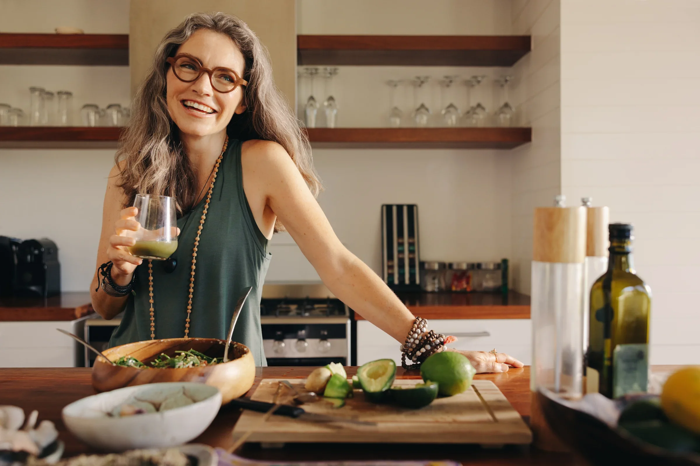 Woman holding a beverage in a kitchen. 
