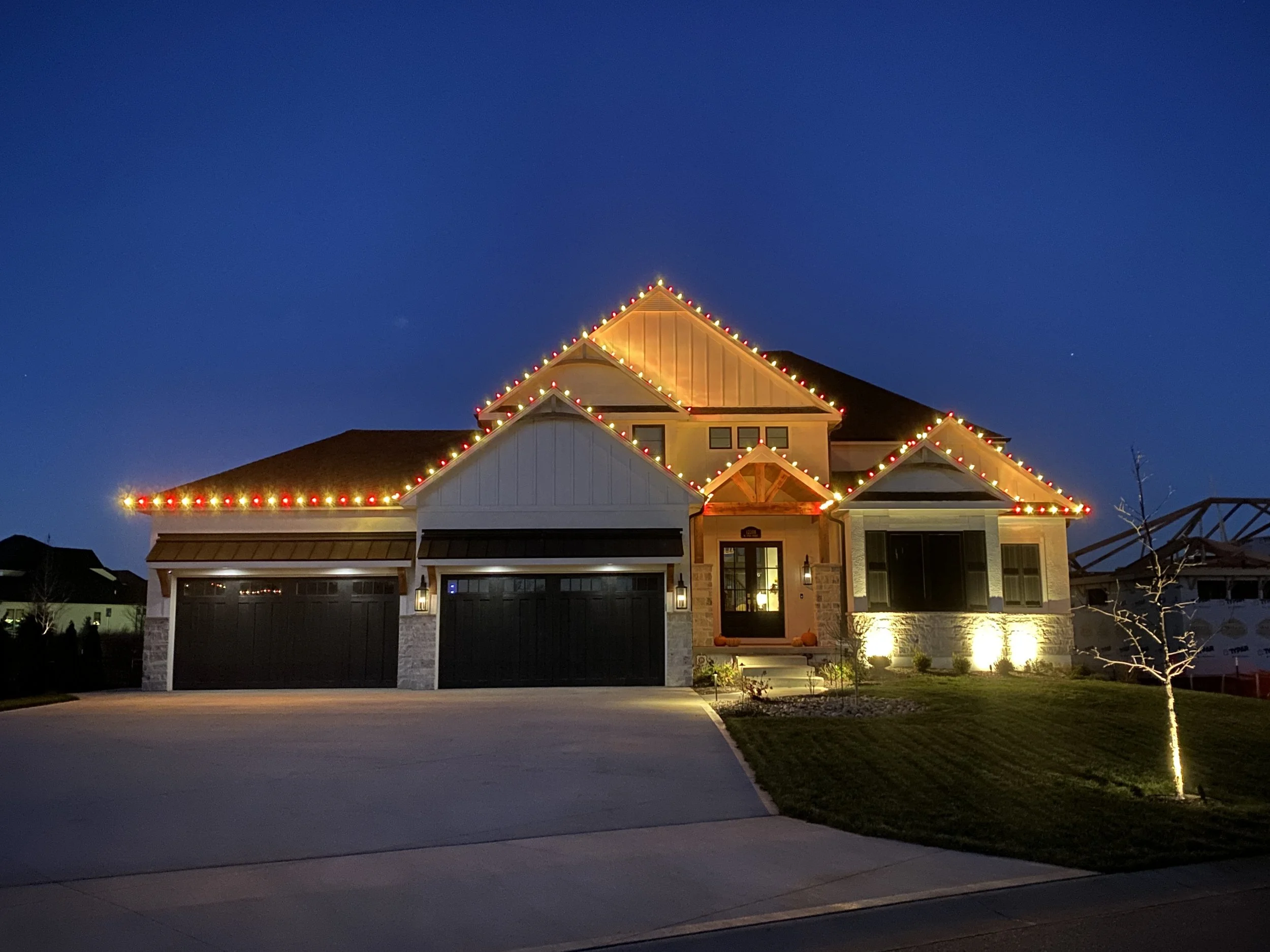 2 story house with 4 car garage Red and Warm white Christmas Lights