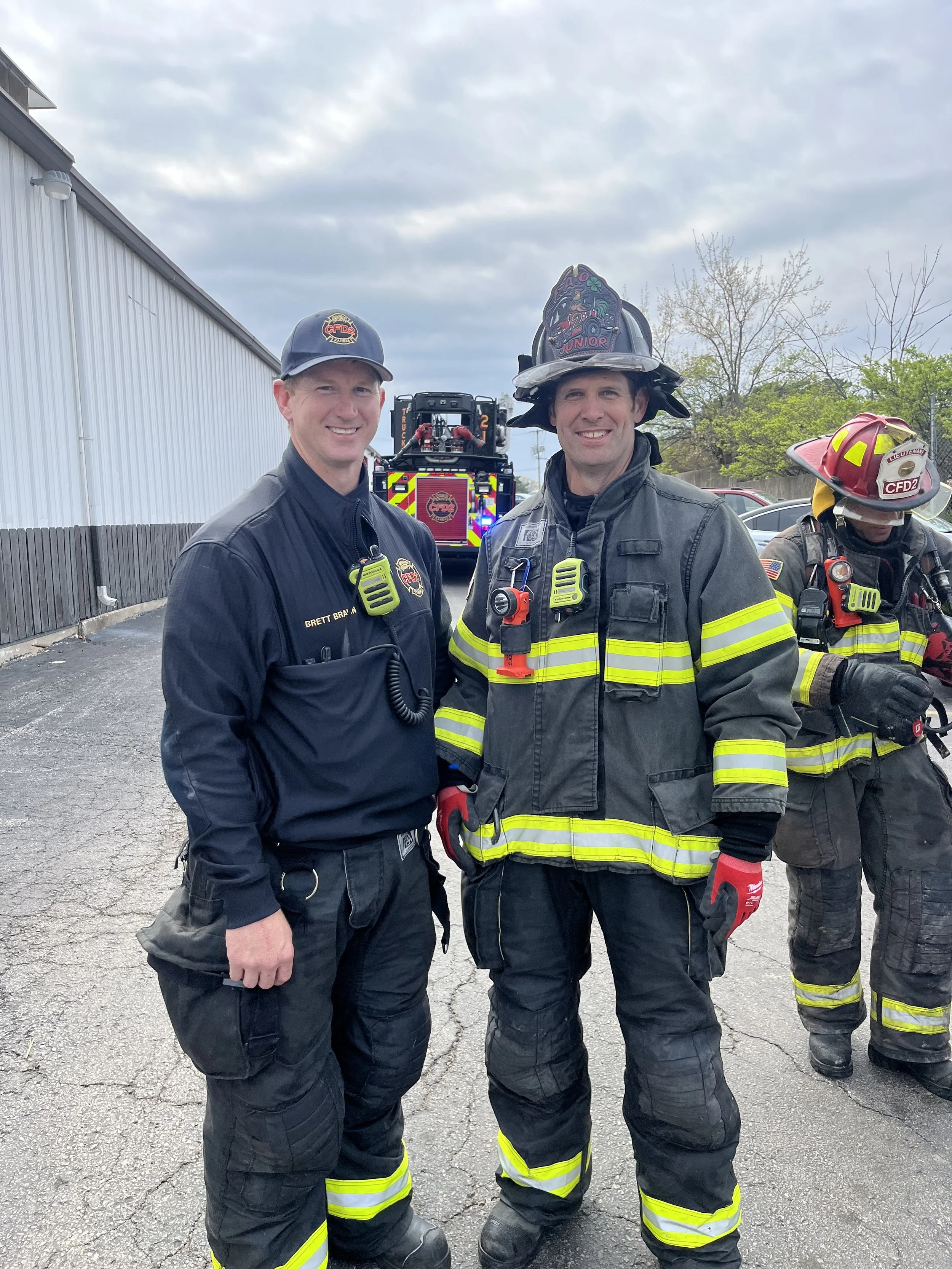 Two Firefighters in Turnout gear after a fire outside