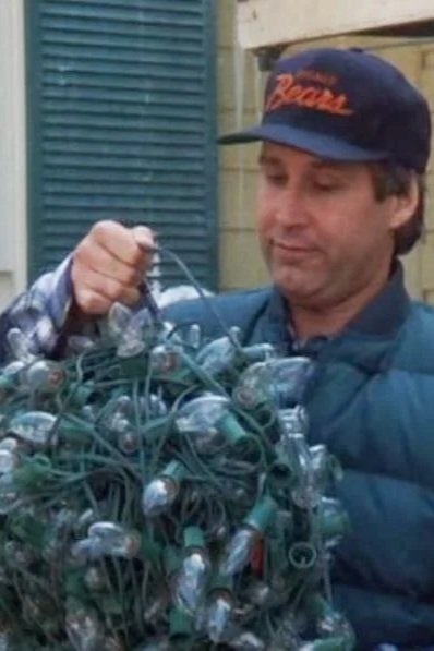 Plaza Lights team member humorously tangled in string lights, a nod to the movie Christmas Vacation