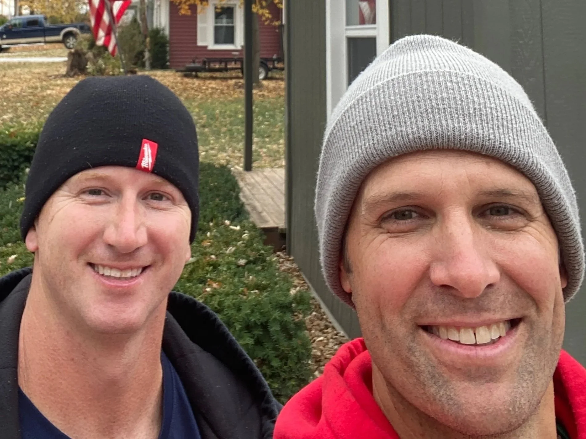 Christmas light installers happy wearing stocking hats