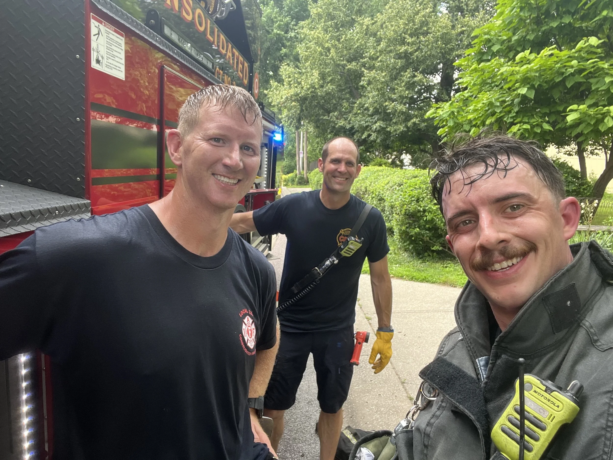 Plaza Lights team members Brett, James, and John standing together at CFD2 fire station