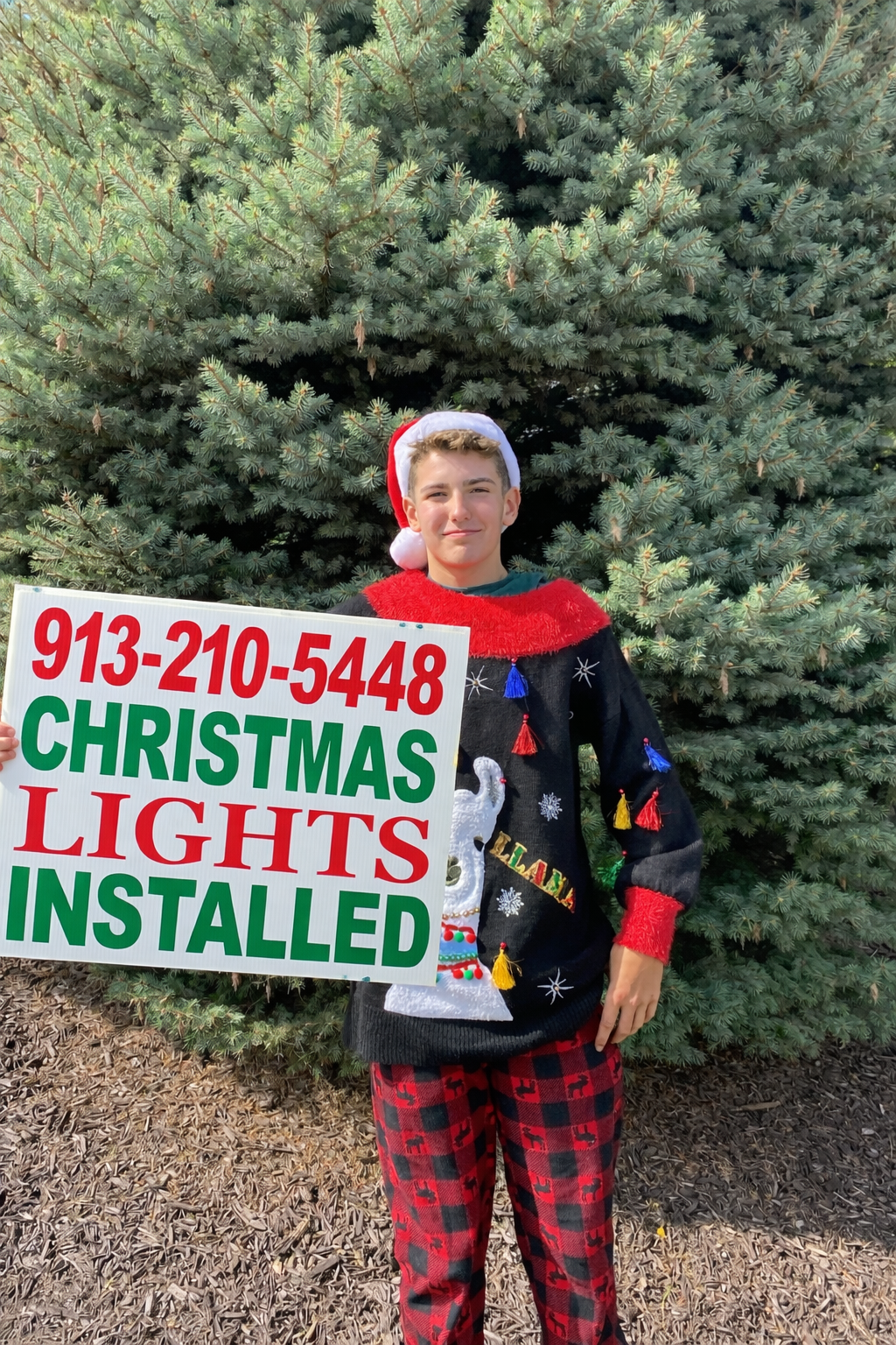 Plaza Lights Christmas light installer holding a sign in Leawood KS