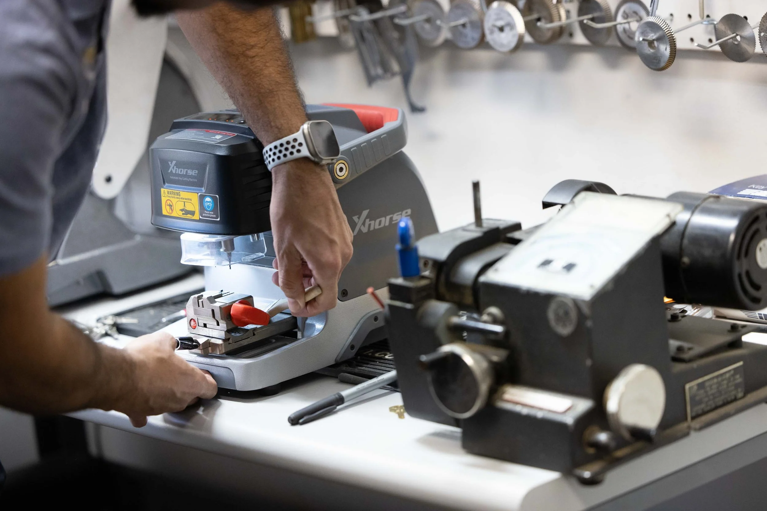 Locksmith preparing a key on a key cutting workstation in a Harrisonburg VA shop for accurate key duplication.