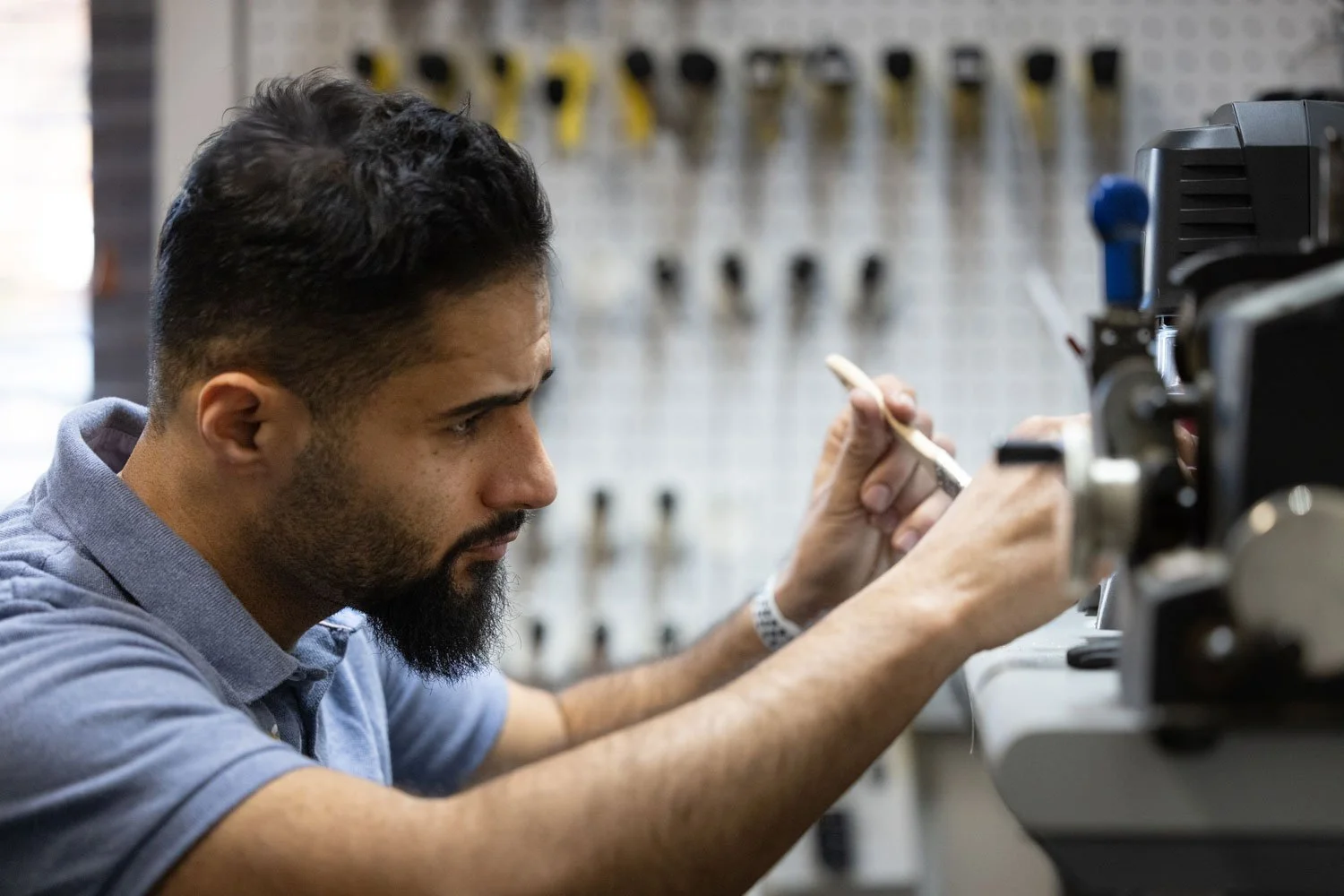 Professional locksmith cutting keys in shop at B.C. Lox and Keys in Harrisonburg Virginia.