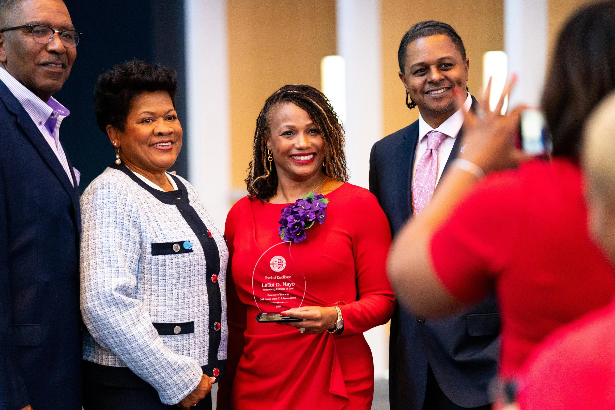 Smiling award recipient in a red dress during a formal ceremony at the UKY Gatton Student Center, captured by Lexington event photographer 859 Photography.