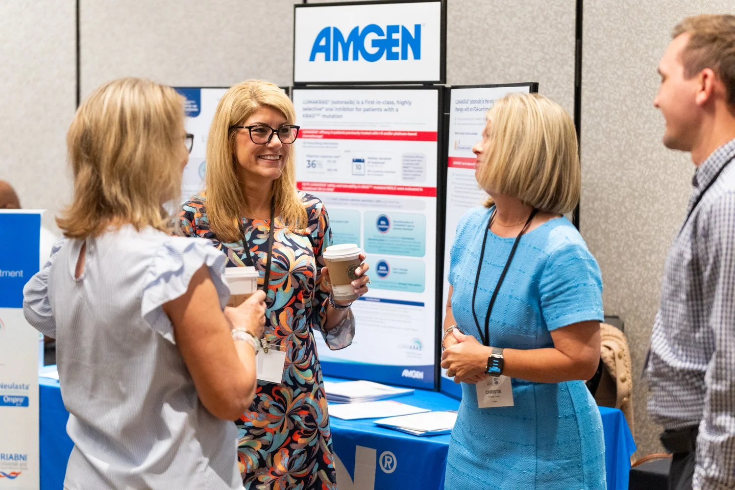 Networking and engagement at an Amgen exhibition booth during a Lexington KY trade show, professional candid event photography by 859 Photography