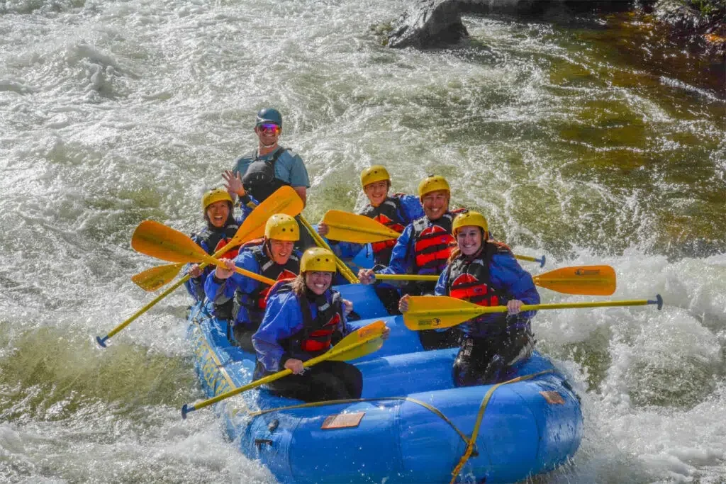 Man riding a fat tire mountain bike on snowy trail, wearing red jacket, helmet, and sunglasses, with snow-covered trees in the background.