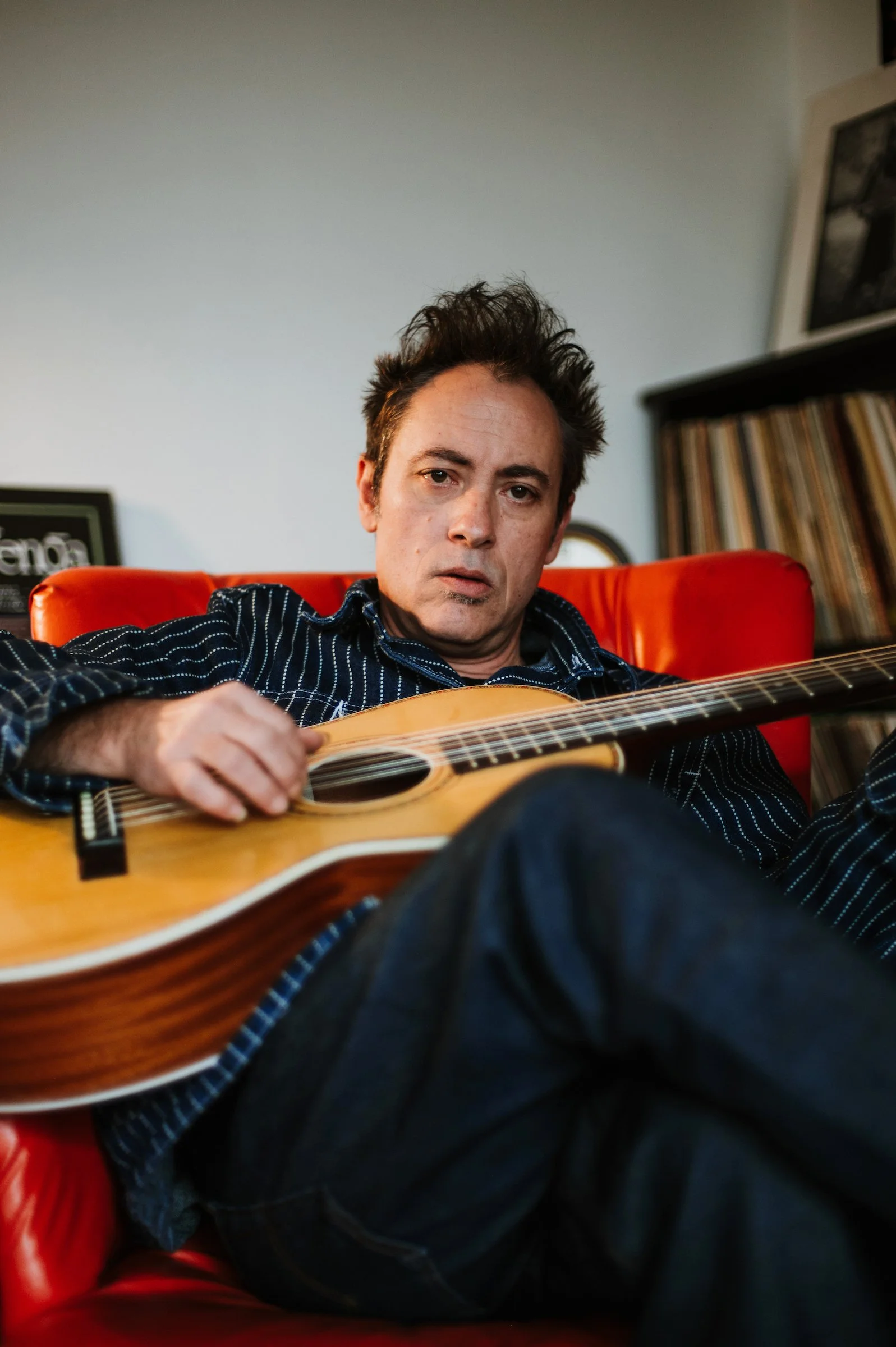 Todd Albright seated with a guitar in his lap