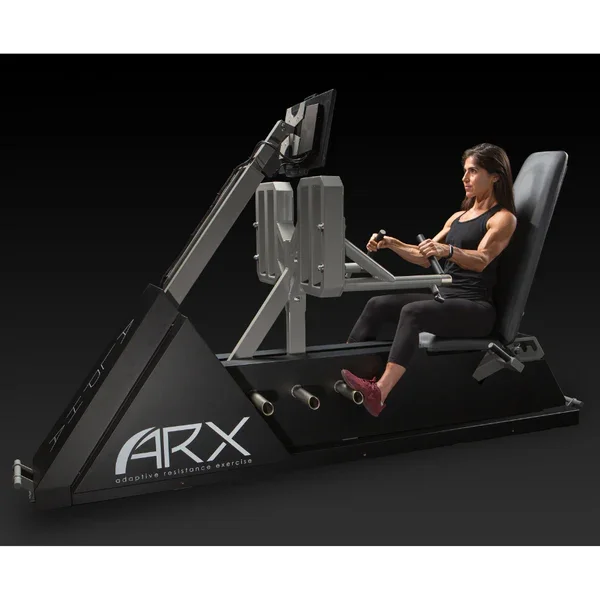 A woman using the ARX adaptive resistance exercise machine in a dark environment.
