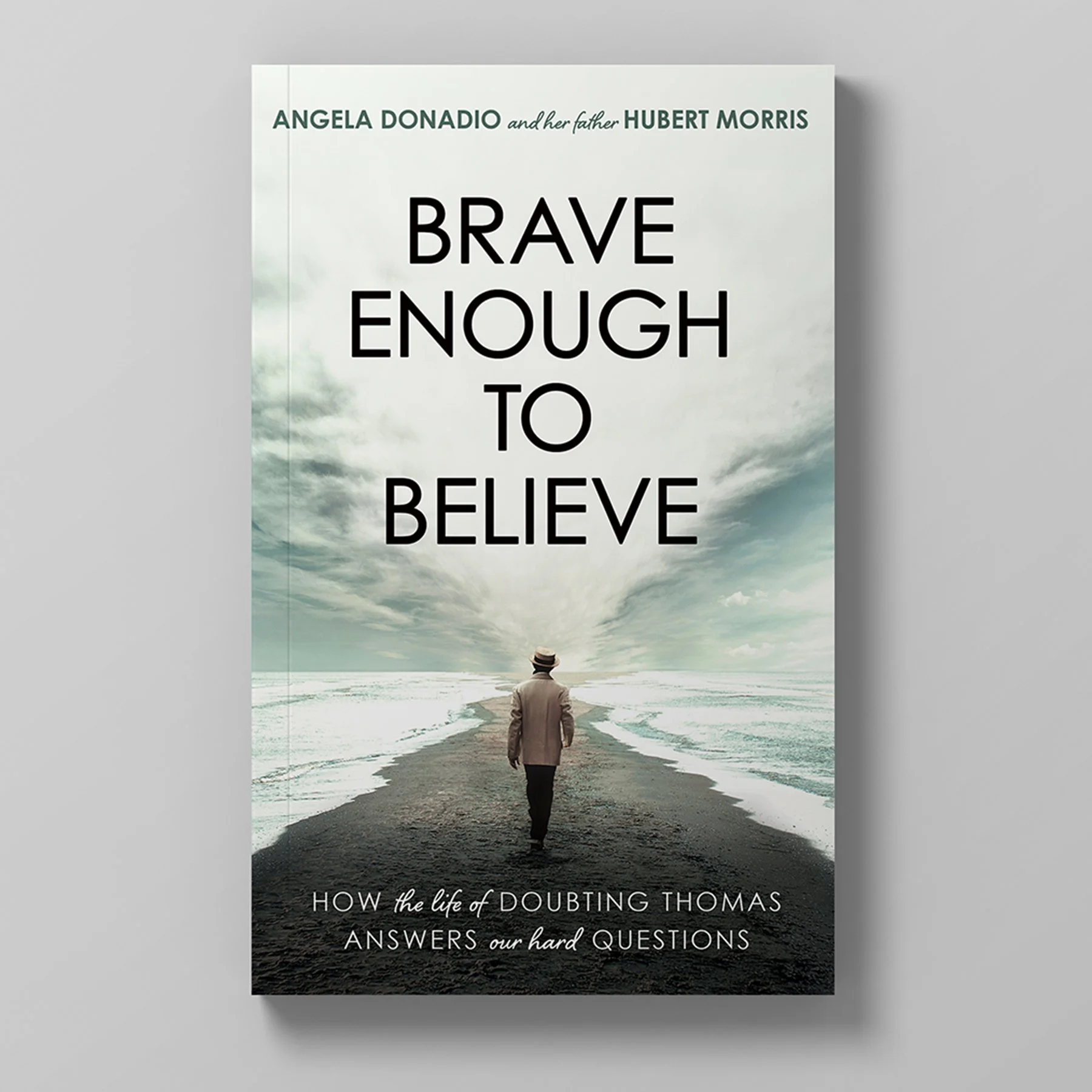Book cover titled 'Brave Enough to Believe' by Angela Donadio and Hubert Morris, featuring a person walking on a pathway by the ocean under a cloudy sky.
