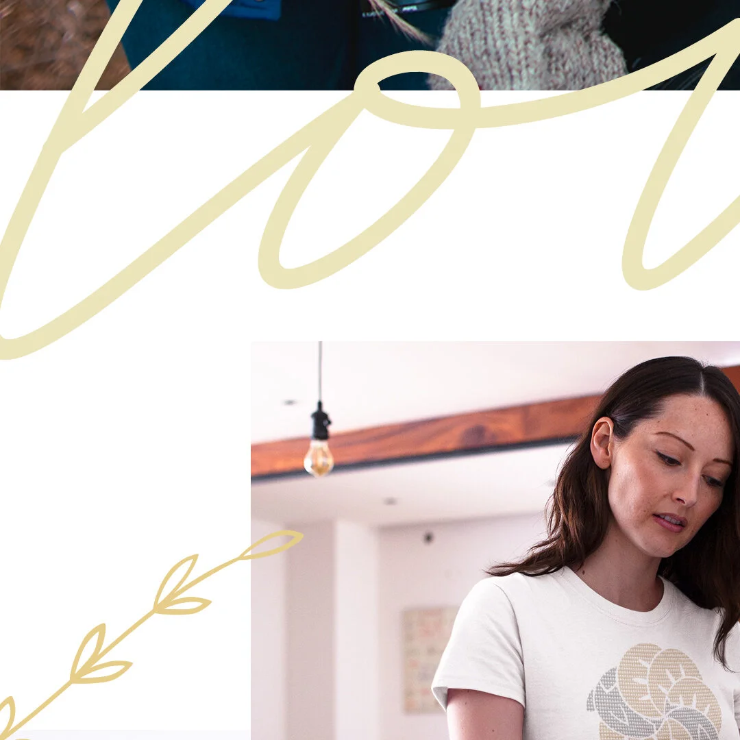 A woman with long brown hair looking down in a room with white walls, wooden beams, and a hanging light fixture.