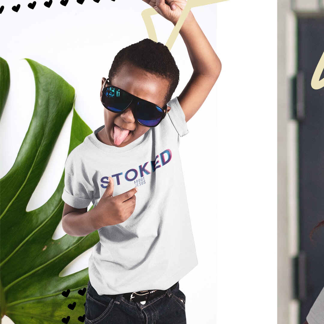 Young boy wearing sunglasses, sticking out tongue, pointing to his t-shirt that says 'STOKED ABOUT JESUS,' with a large green leaf behind him and small black hearts near the top of the image.