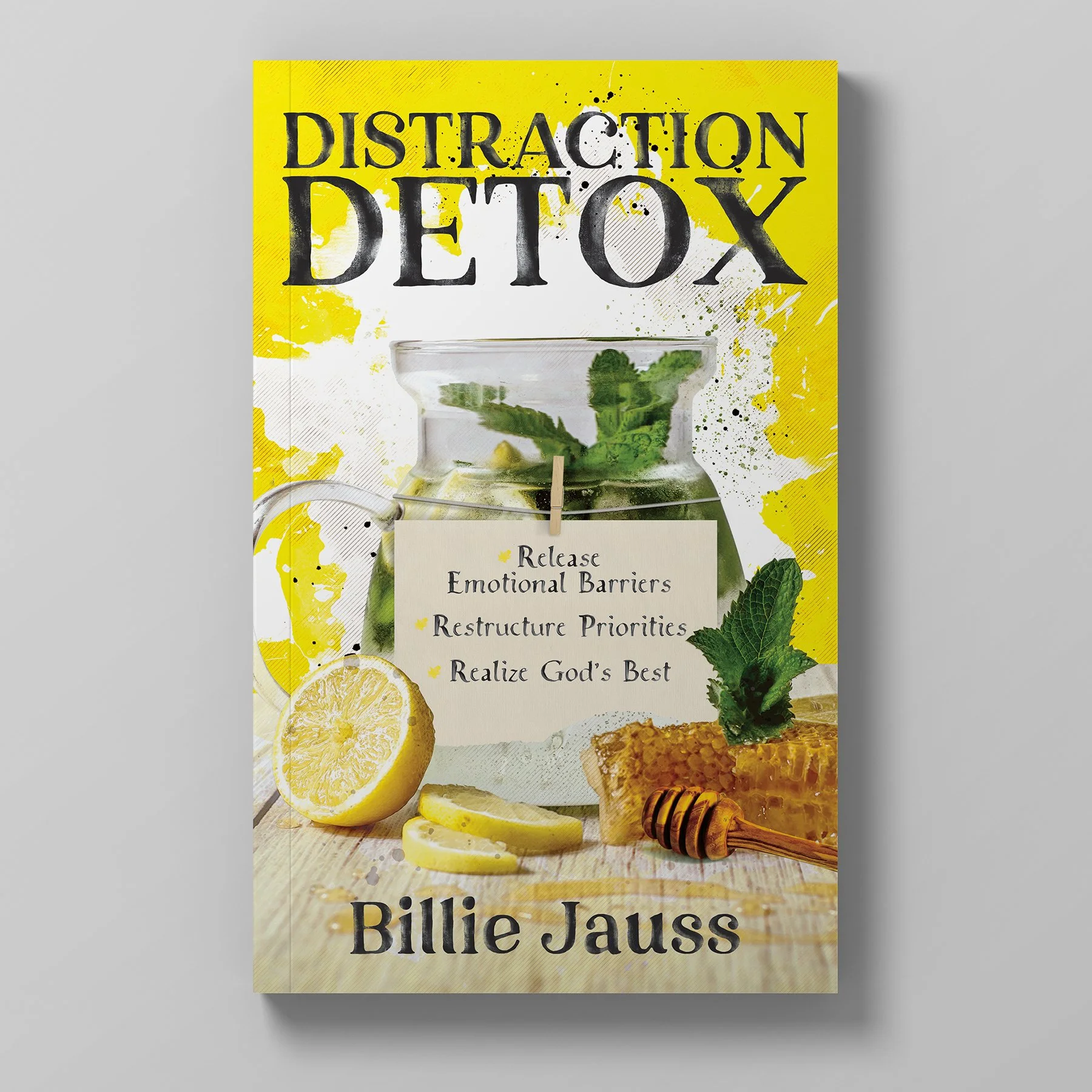 Book cover titled "Distraction Detox" by Billie Jauss featuring a glass teapot with fresh mint and lemon slices, honeycomb, and lemon slices on a wooden surface, with a yellow splash background.