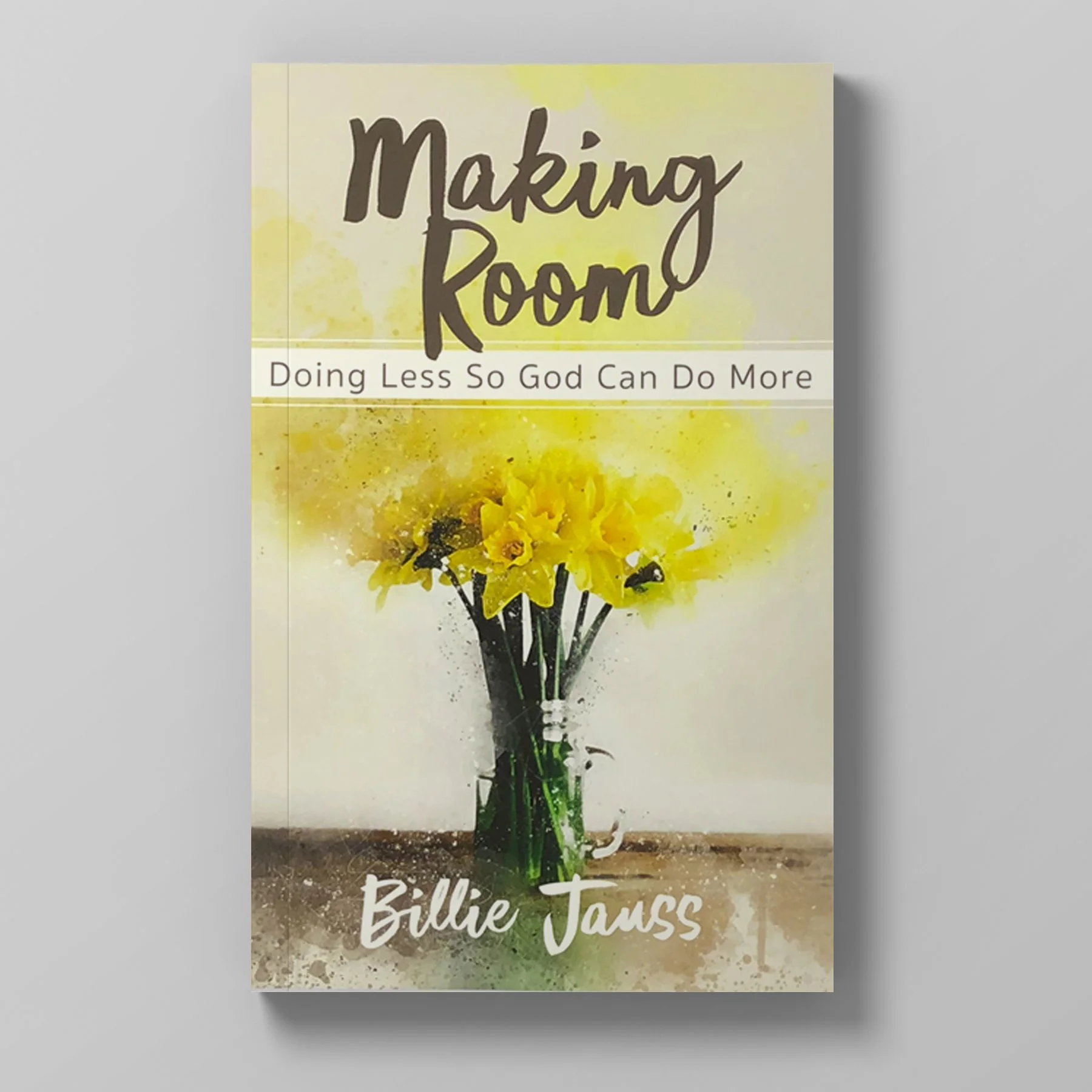 Book cover titled 'Making Room' with a subtitle 'Doing Less So God Can Do More.' The author is Billie Jauss. The cover features a bouquet of yellow daffodils in a dark green vase on a wooden surface. The background is light with a watercolor effect.