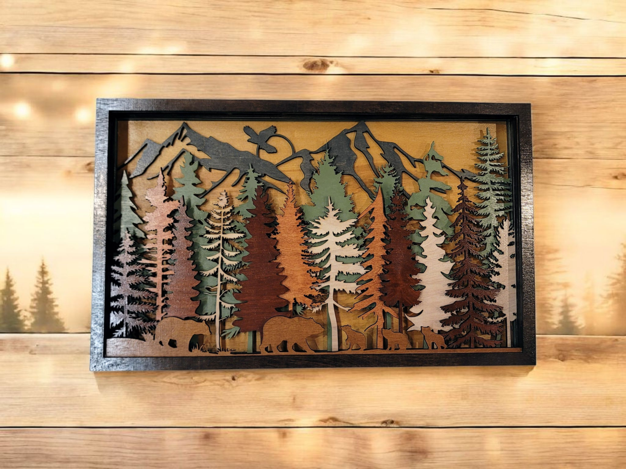 Wooden wall art featuring a mountain landscape, pine trees, and bear silhouettes.