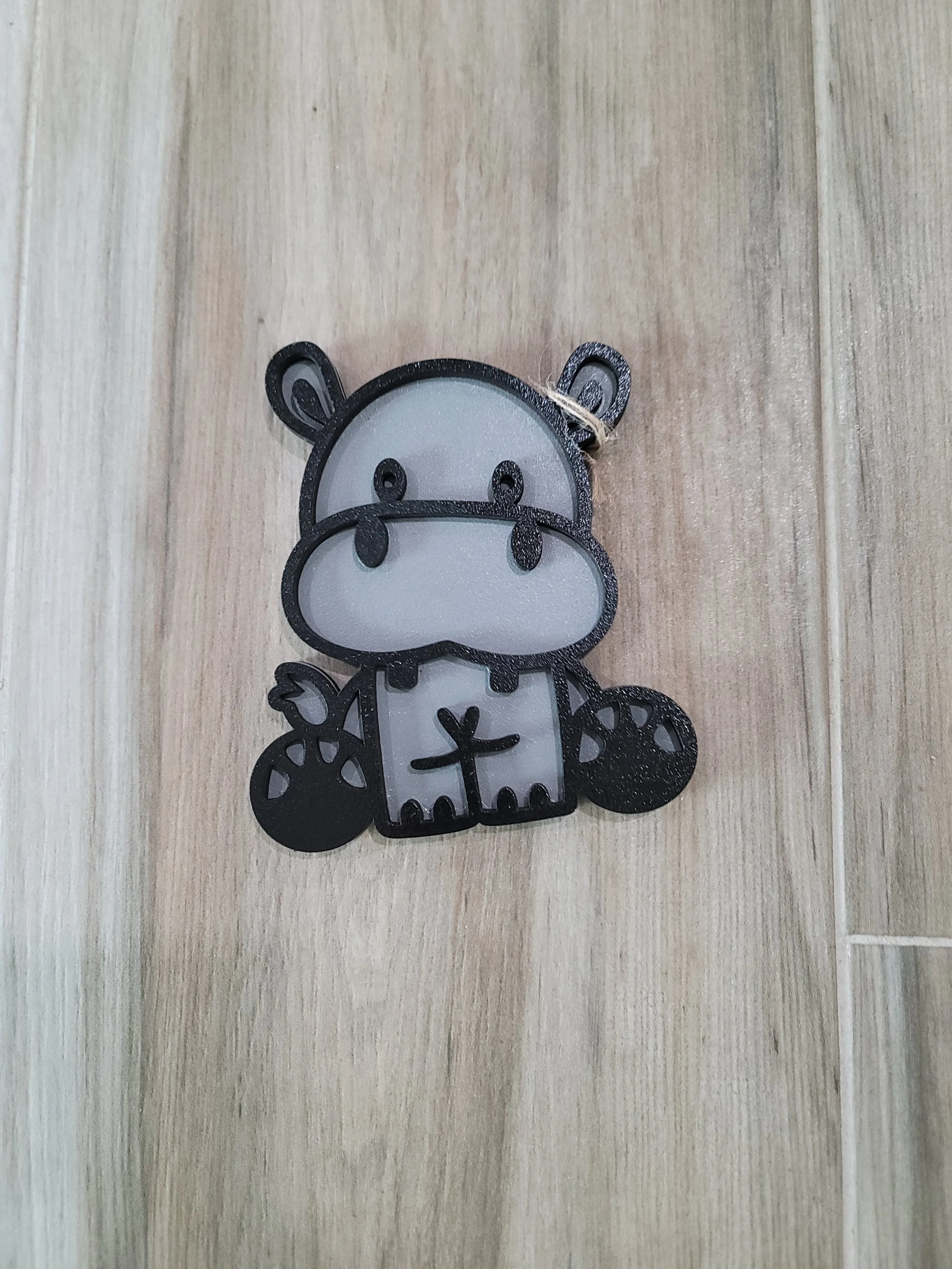 Cute cartoon hippopotamus with black outlines and white face, feet, and body