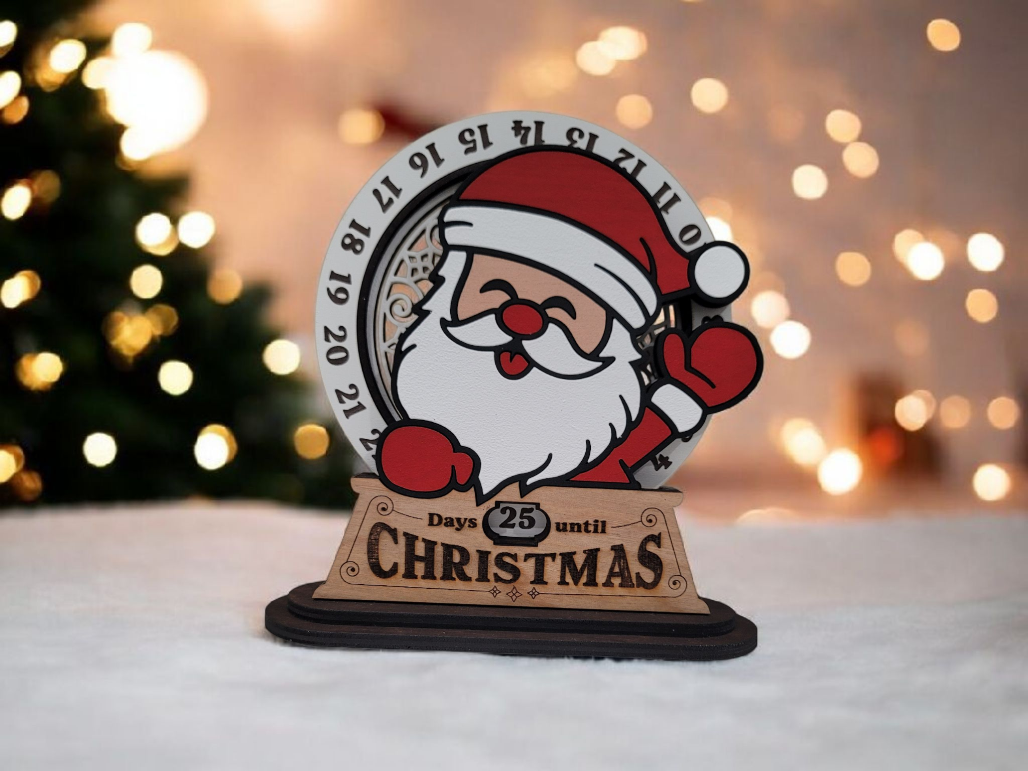 A Santa Claus-themed countdown sign showing 25 days until Christmas. The sign features a cartoon Santa with a red hat, white beard, and red gloves, in front of a background with Christmas lights and a decorated tree.