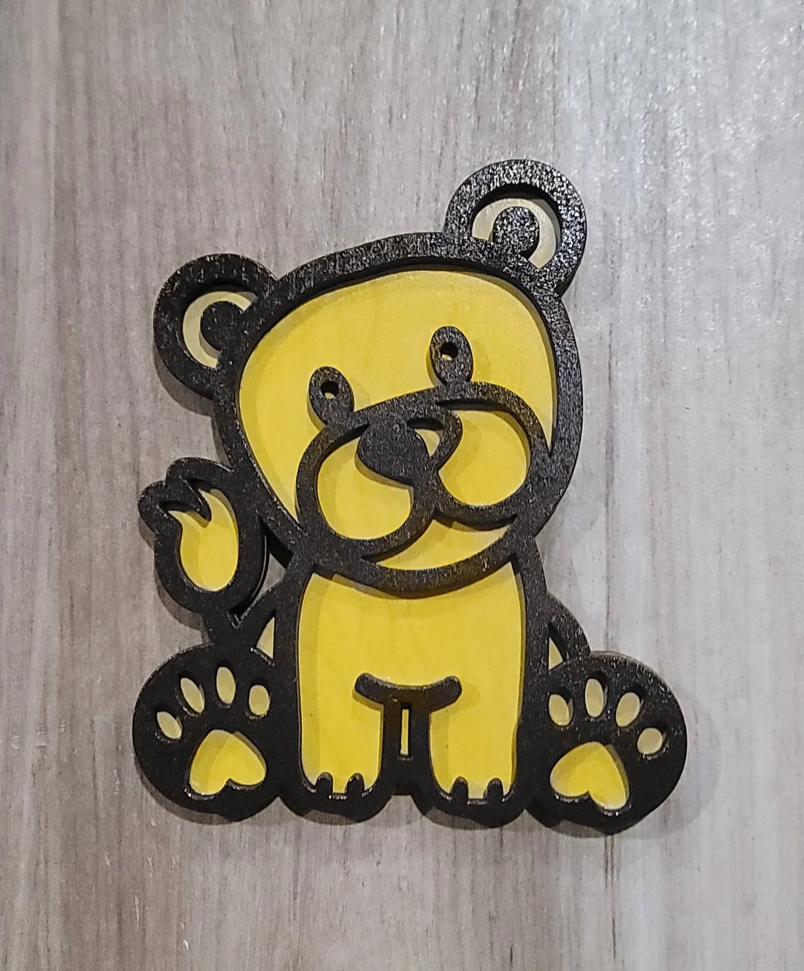 Decorative teddy bear with yellow body and black outline