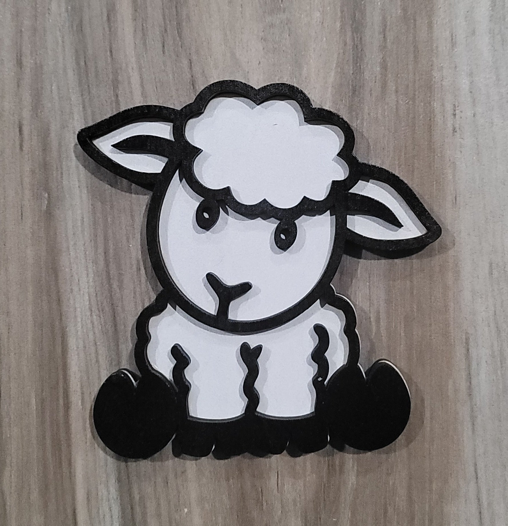 Cute cartoon sheep with a fluffy white head, black eyes, and a black nose