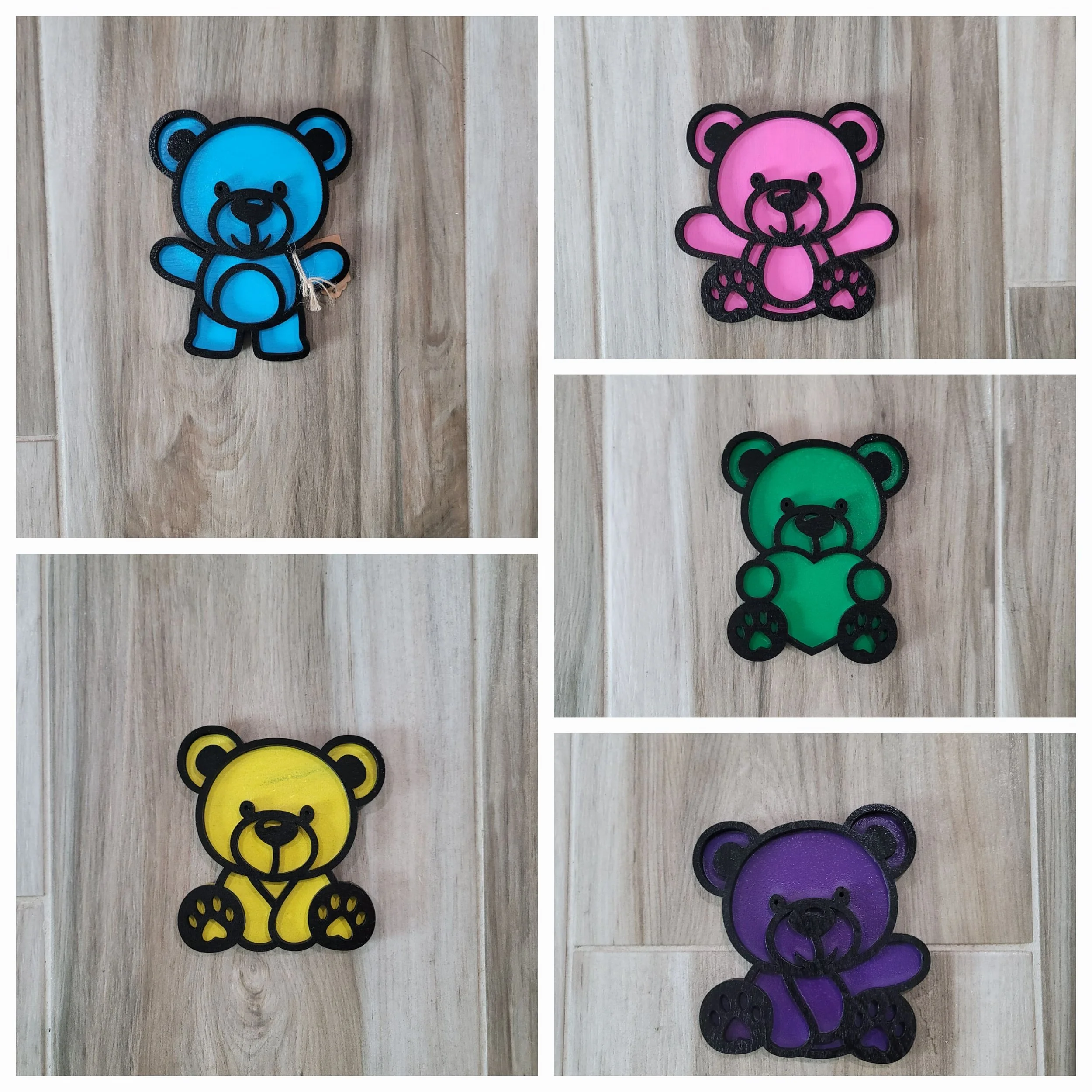 Set of five colorful bear-shaped patches in blue, pink, green, yellow, and purple on a wooden surface.