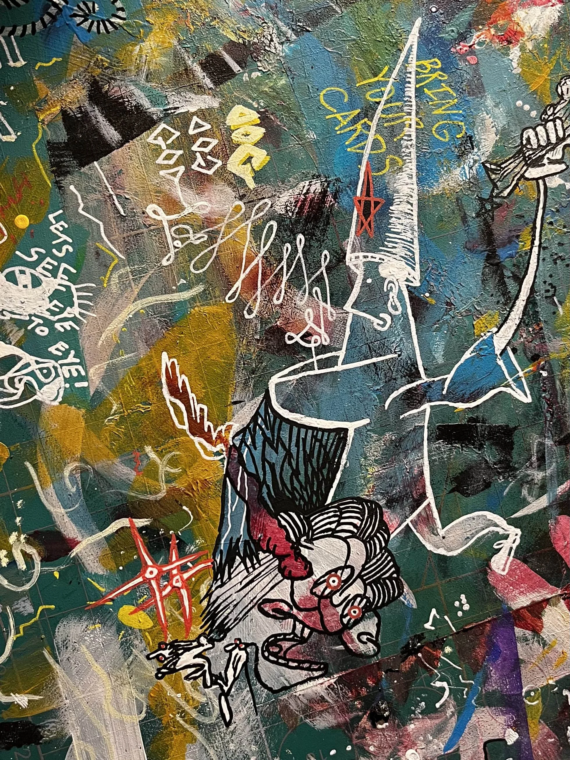 Abstract graffiti art featuring a white and black illustrated figure with a face, sharp features, and a hat, surrounded by colorful shapes, scribbles, and text on a textured background.