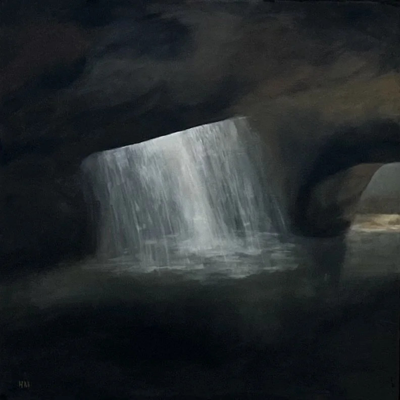 Dark cave with a waterfall flowing through an opening