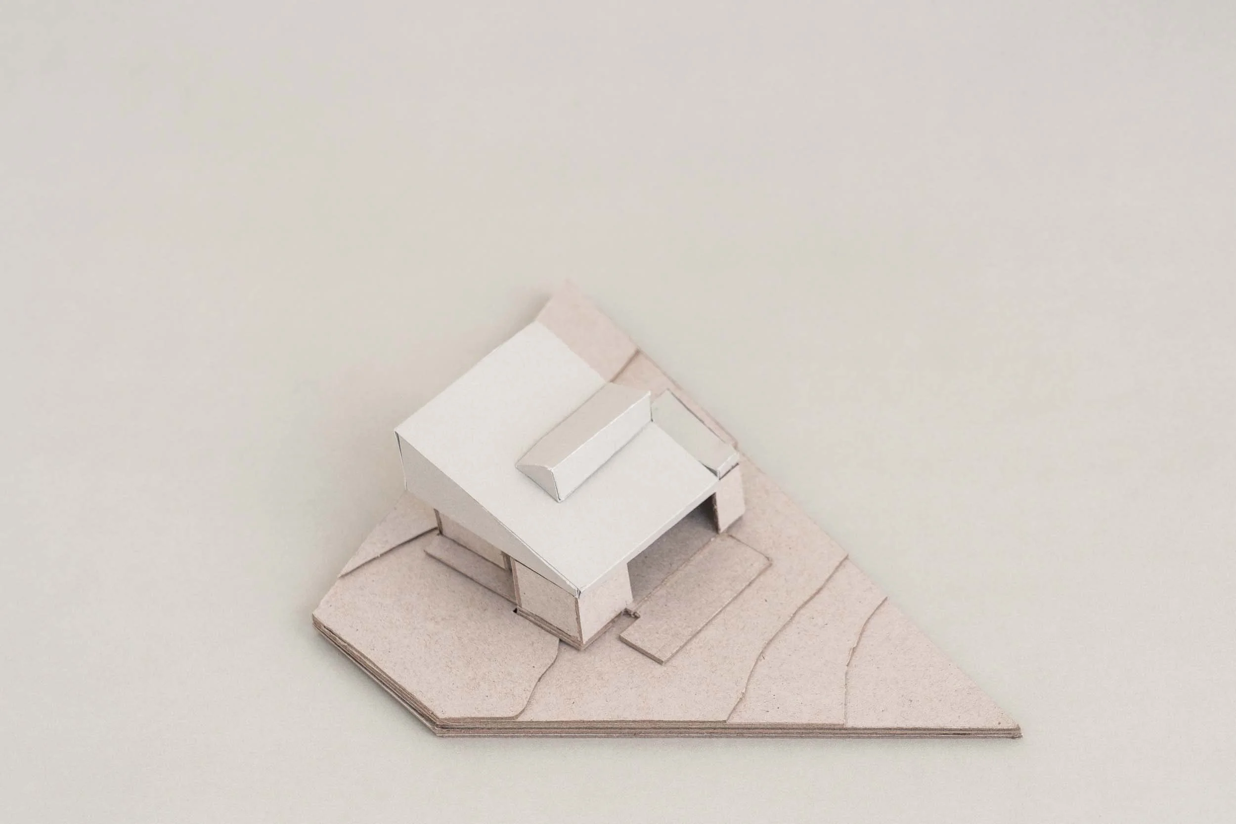 A scale architectural concept model of Lou’s House in Adamstown Heights by Muci. The roof is left on to show the wedge-shaped form of the design.