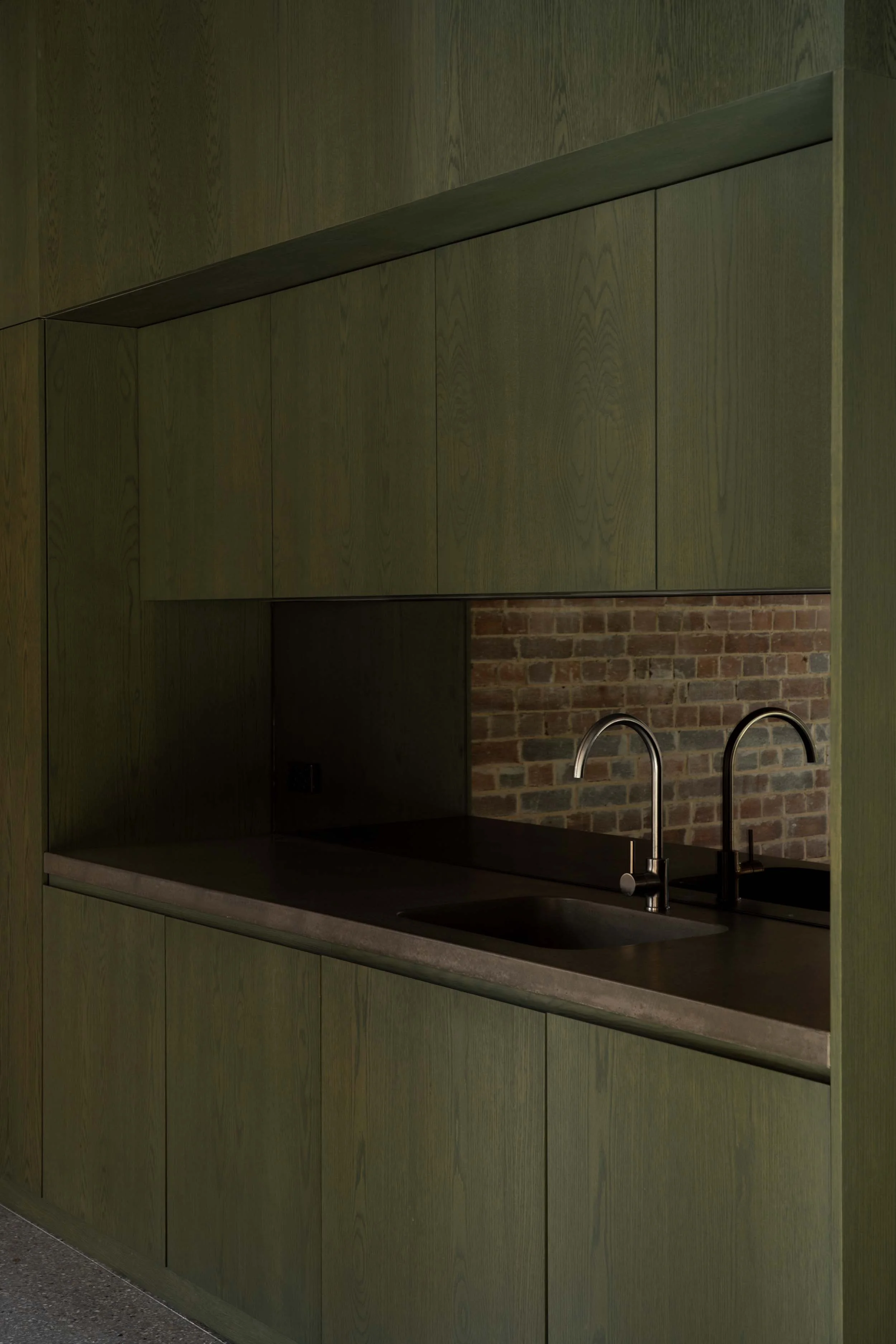 A detail view of green stained timber joinery with dark coloured concrete benchtop. Tap by Astra Walker. The Foundry office fitout in Darlington, by Muci