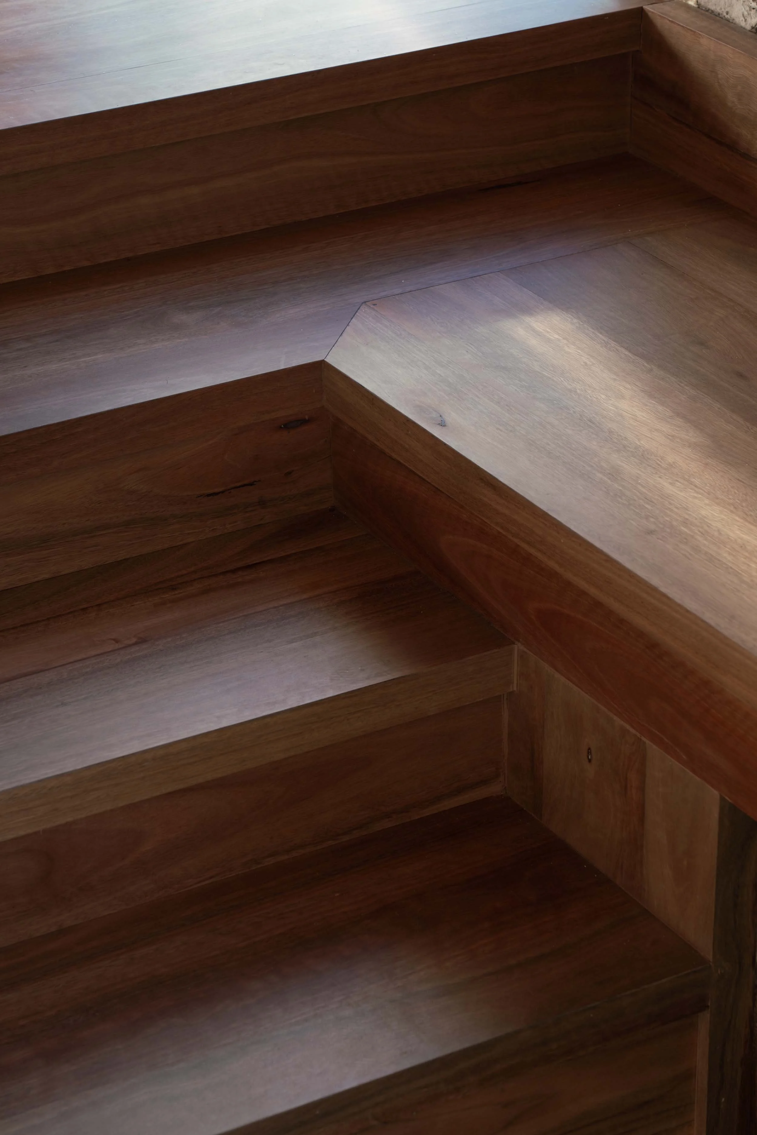 A detailed photo of the stair detail at the entry to The Foundry office fitout by Muci. The stairs are clad in blackbutt flooring from Havwoods and turn to form a bench seat in the same material.