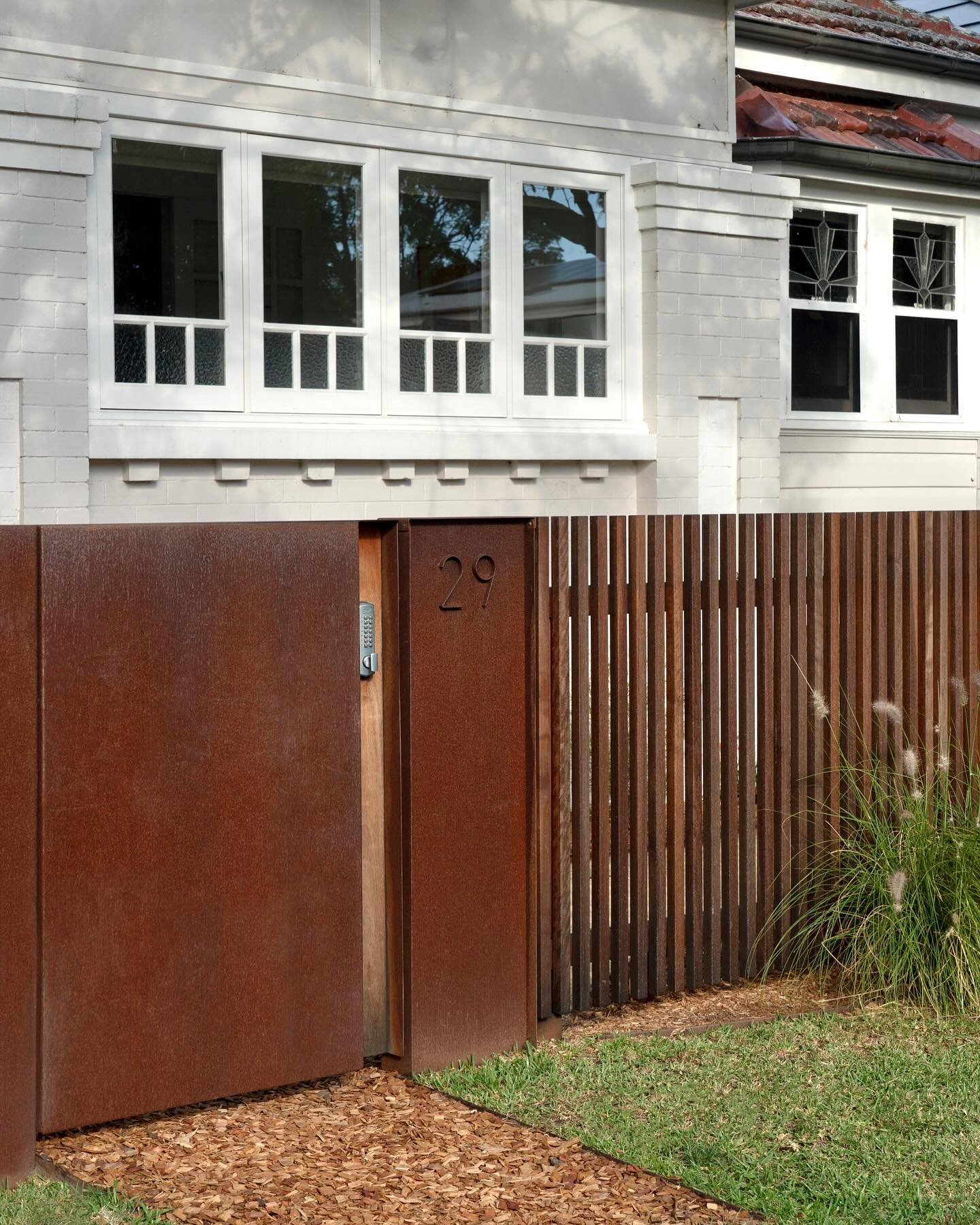 Corten folds around a peice of blackbutt to accommodate the lock and handle.

New windows were also added to transform the front verandah into a sunroom and the Kosciusko glass detail is a nod to the original lead light windows on the adjacent front 