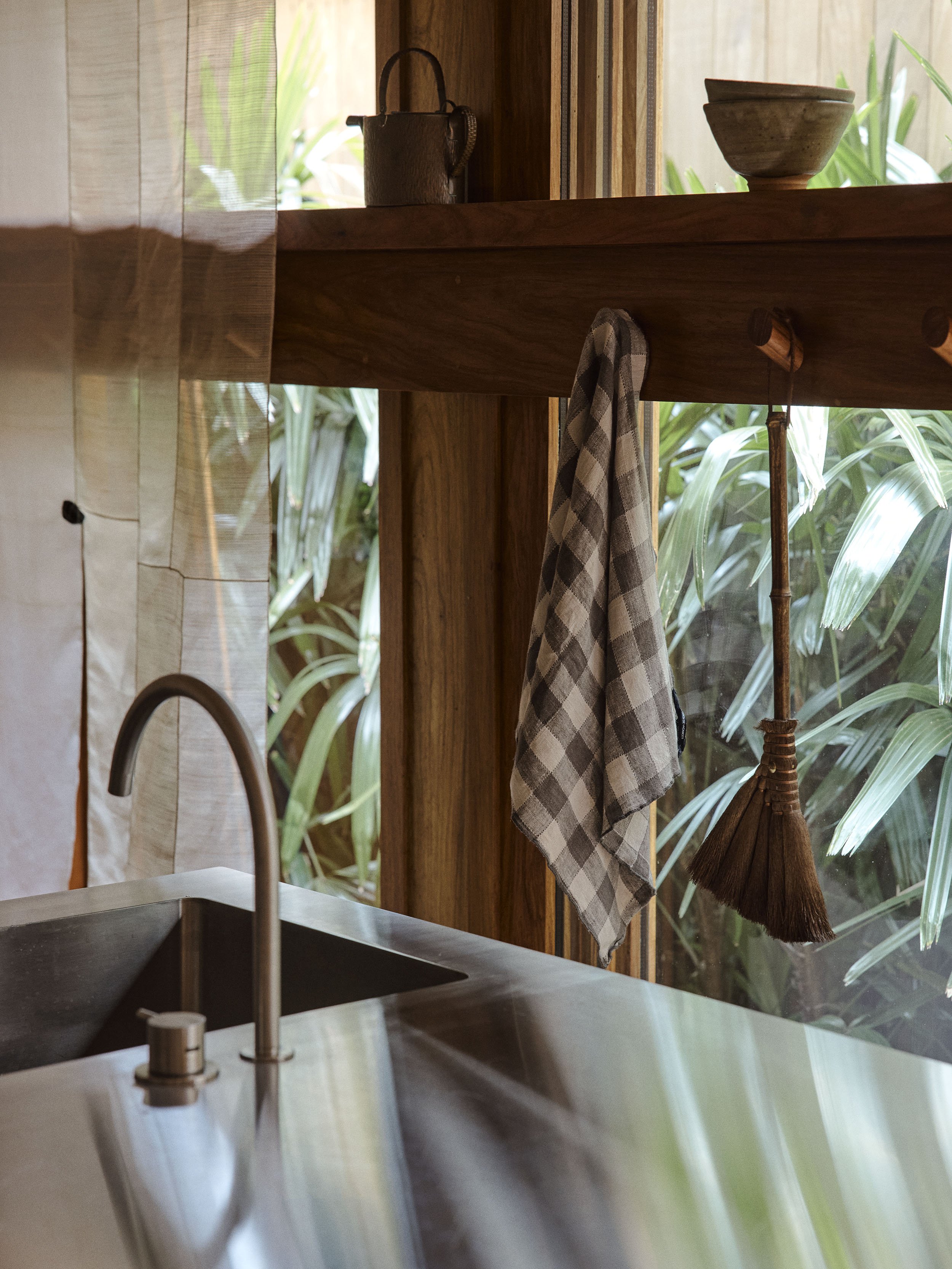 A detailed view of the timber window with hooks and stainless steel kitchen island in the Sydney terrace renovation by Muci architects